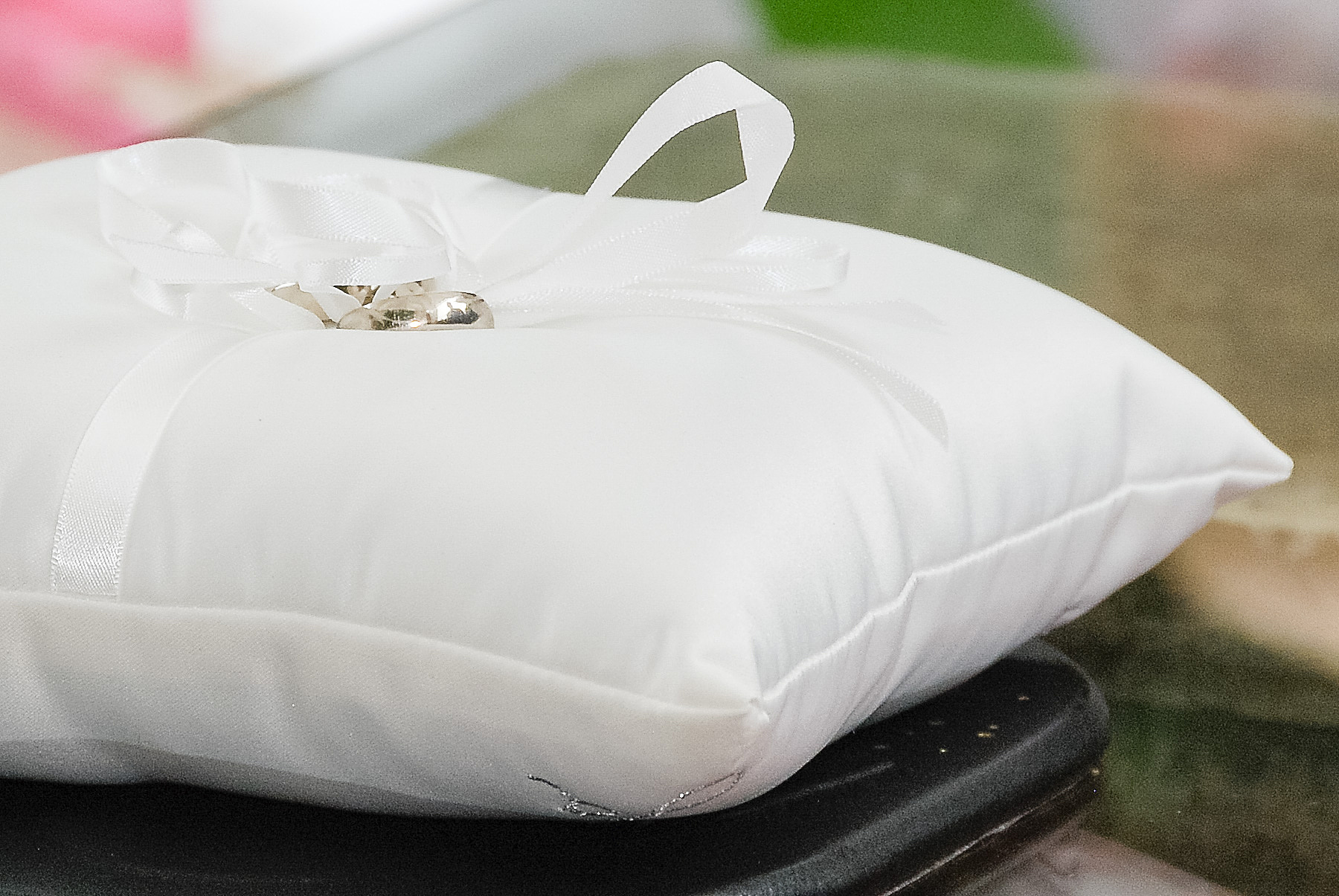 close-up of wedding rings on pillow