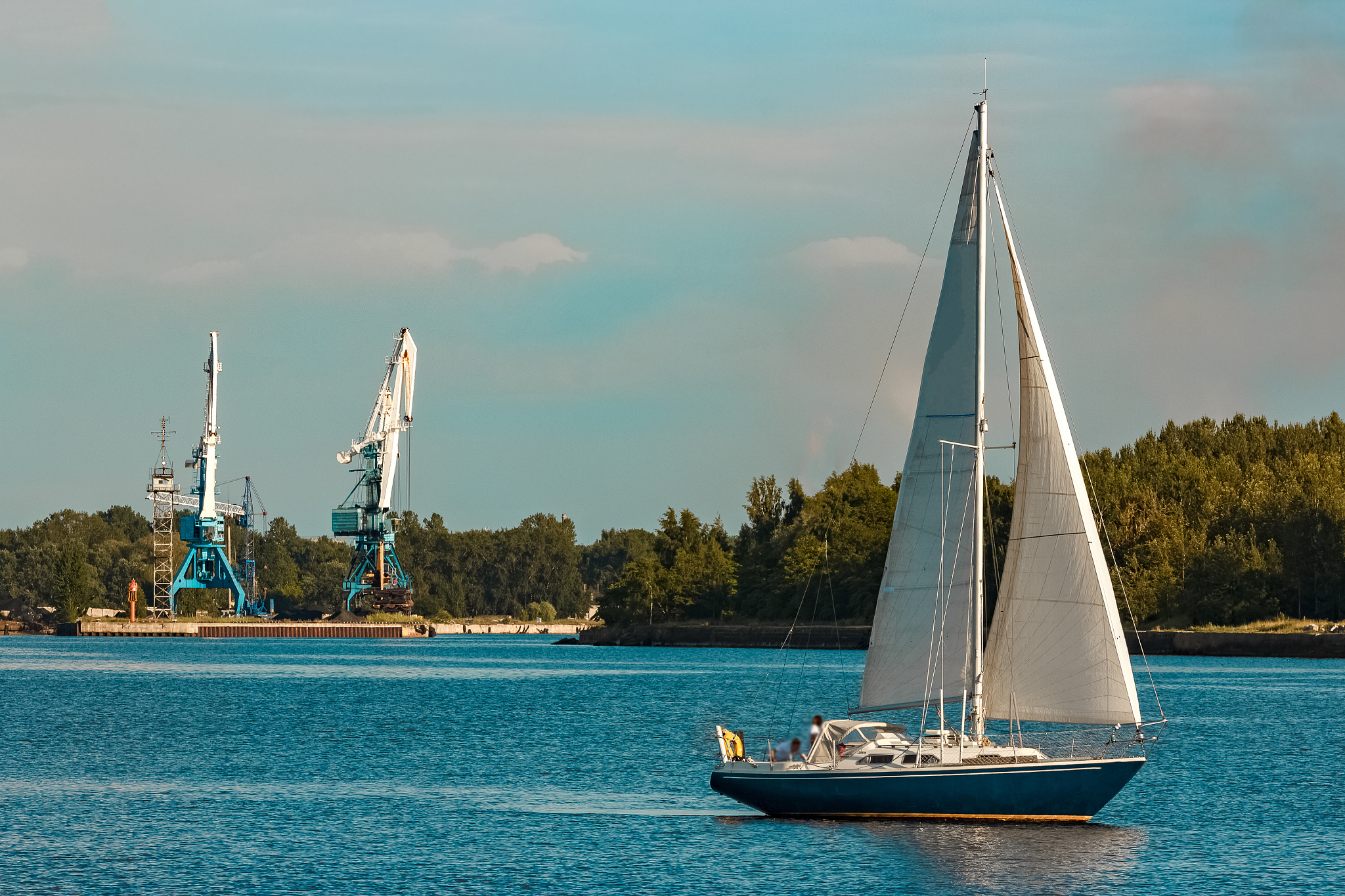 blue sailboat at river
