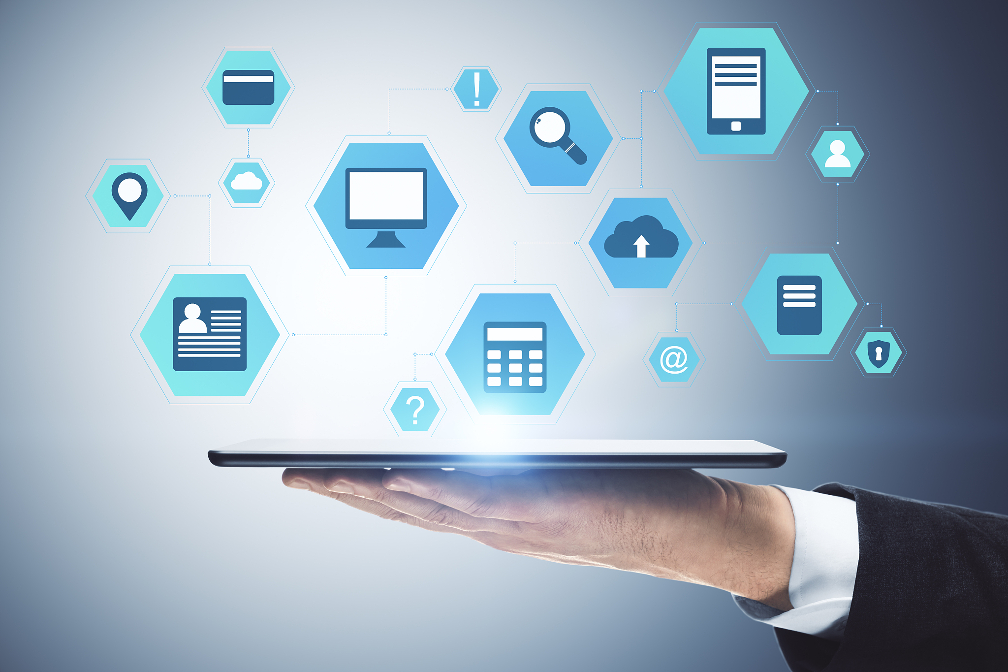 hand holding digital tablet with business interface hologram.