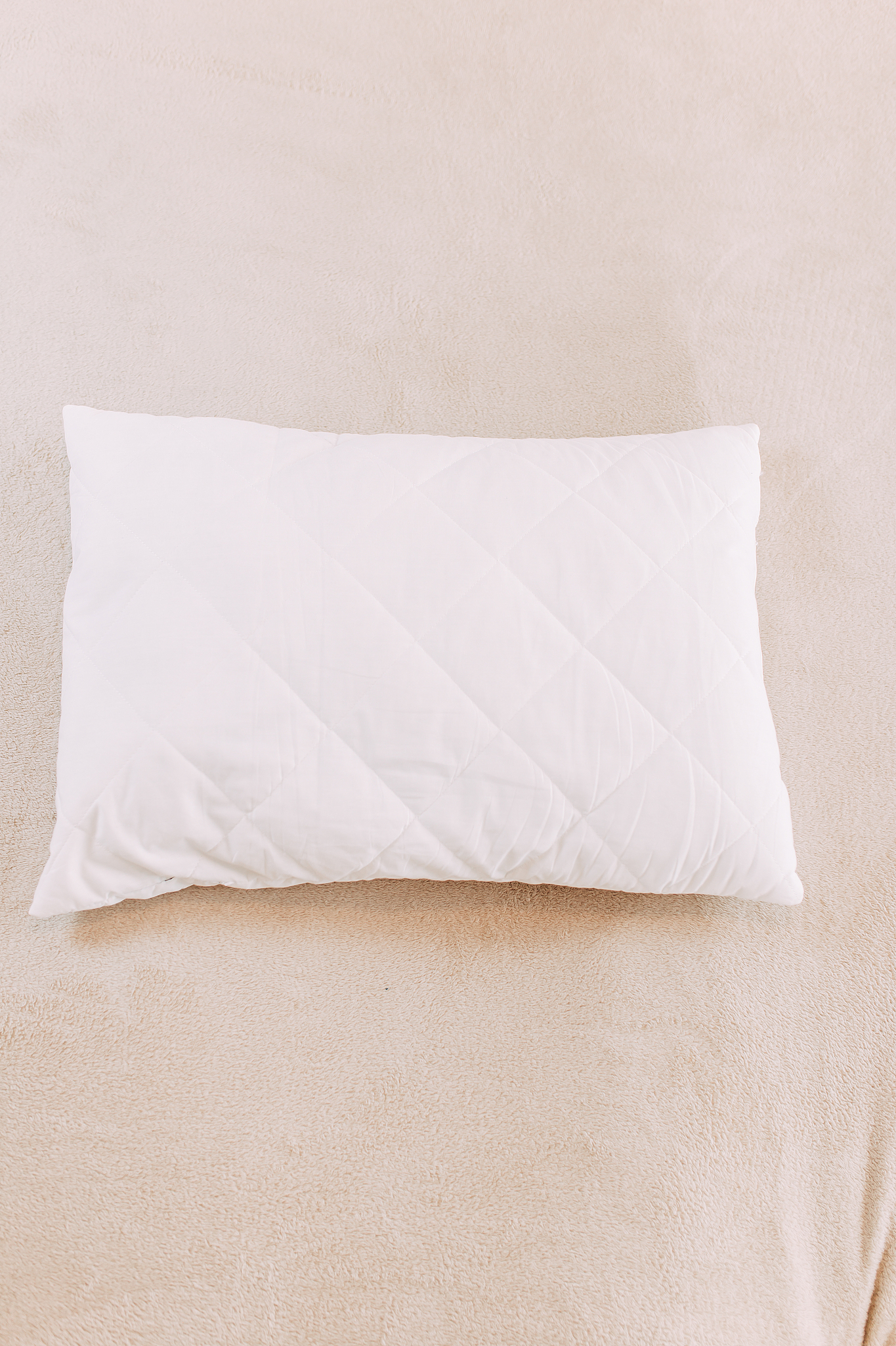 white pillow on the bed, beige plaid, stay home while quarantine