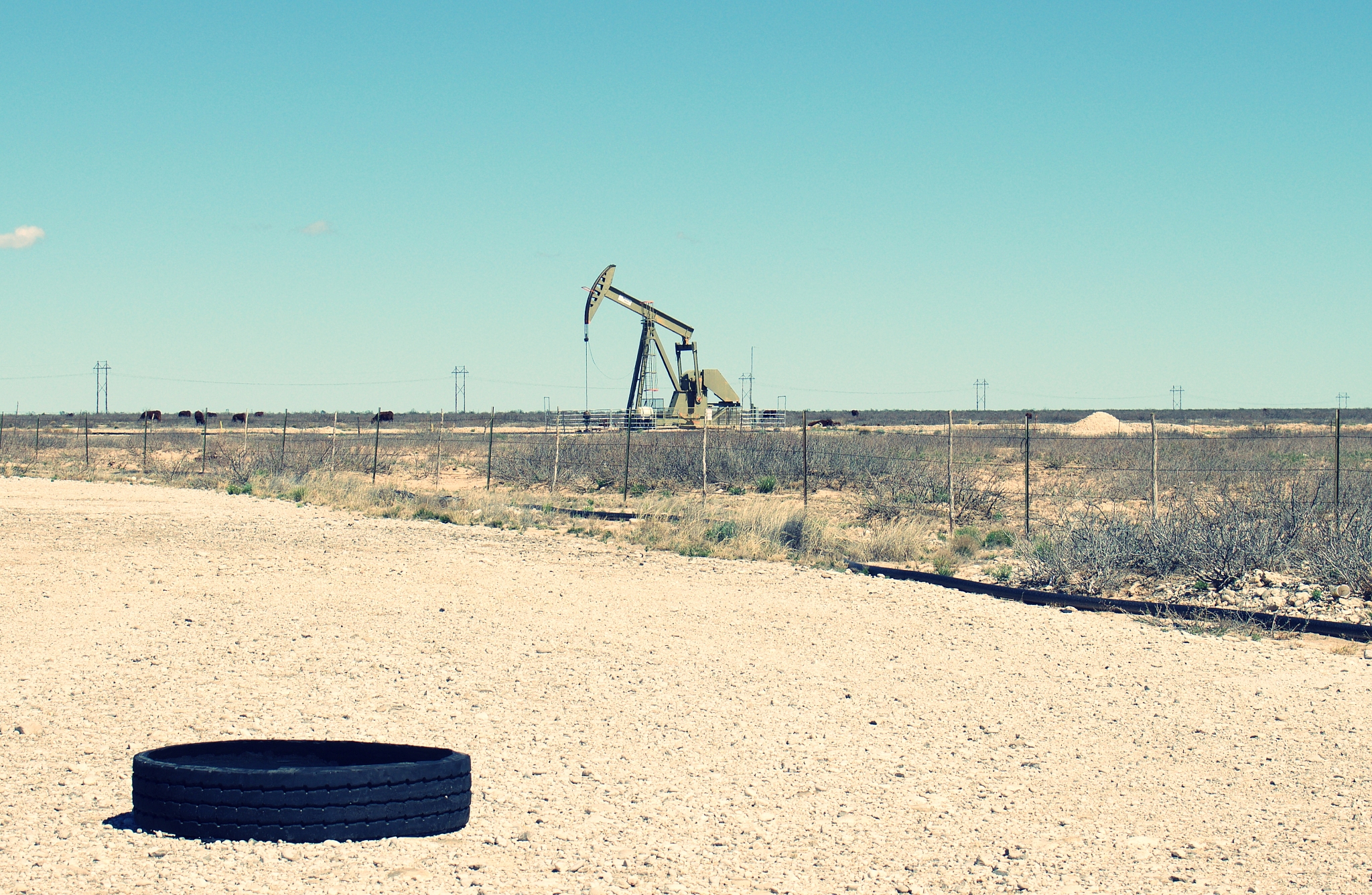 single pumpjack with tire in foreground, it takes about seven ga