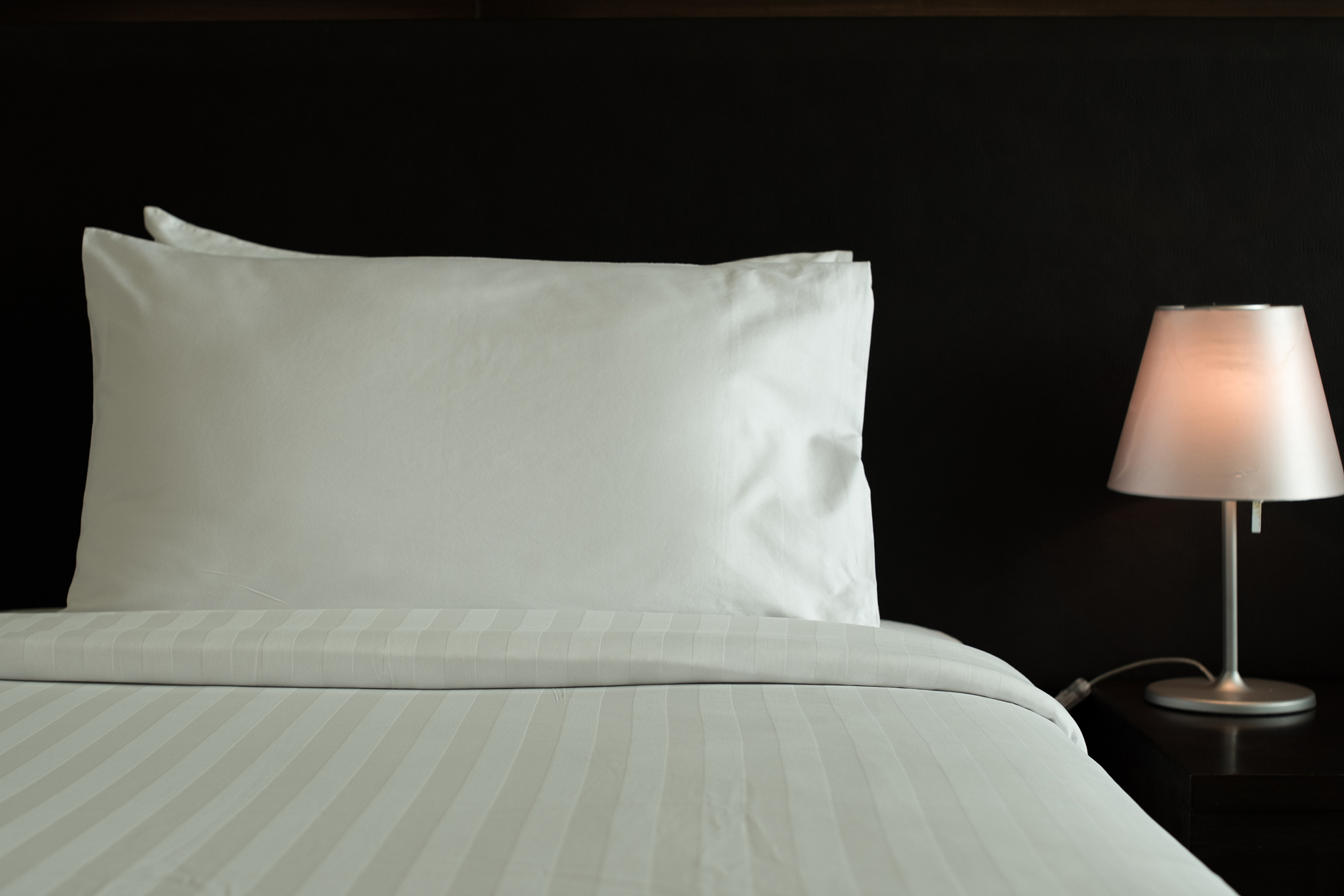 bed and lamp in black background.