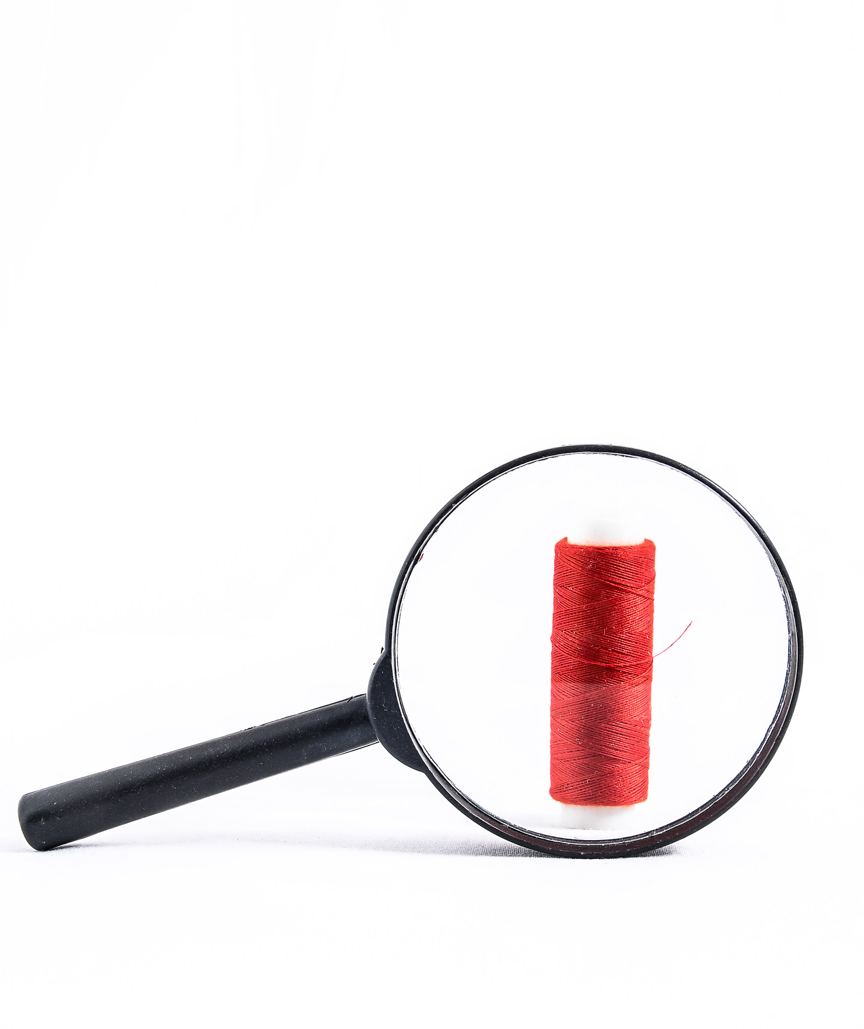 roll of twine and loupe on a white background