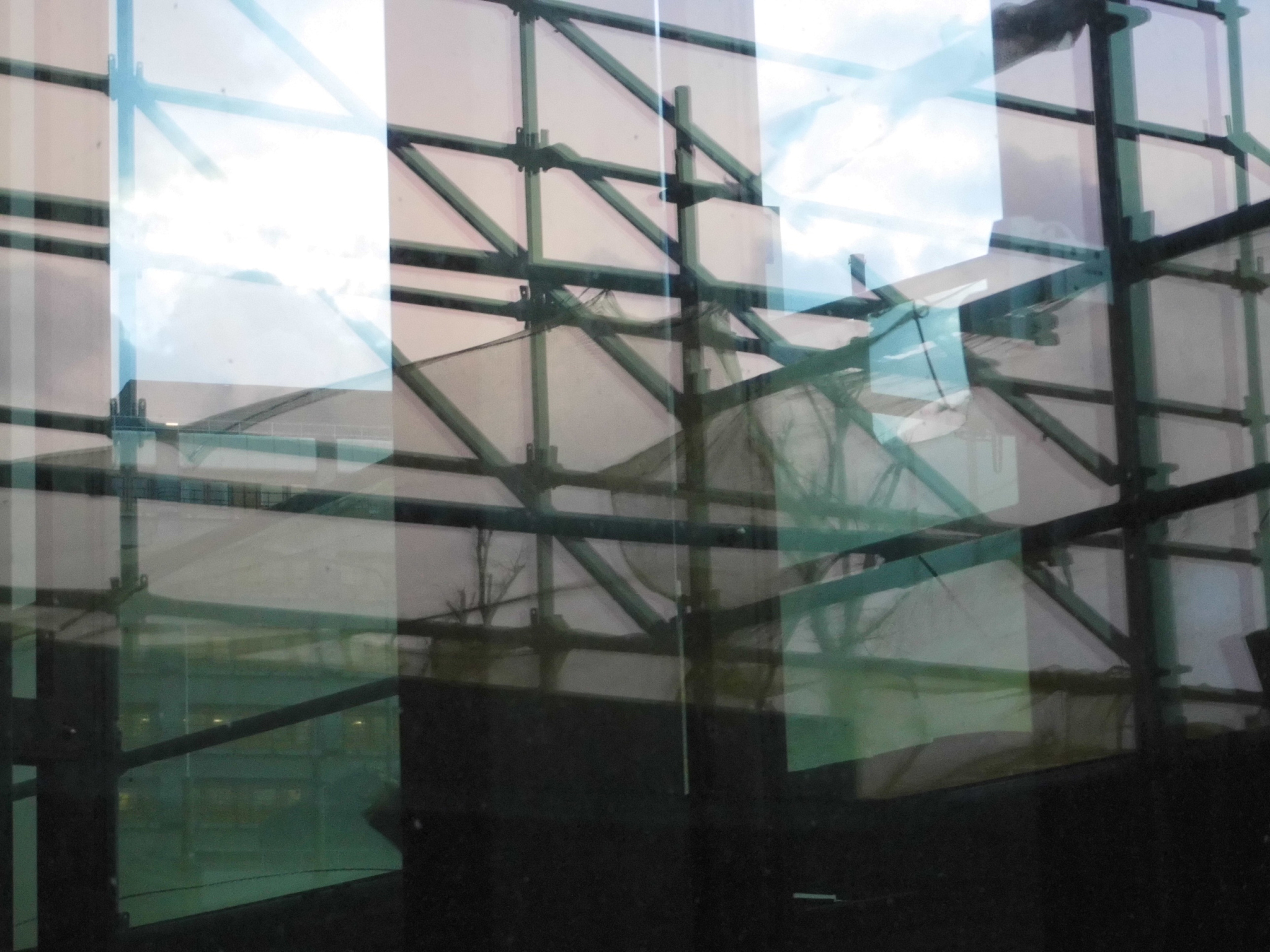reflection of scaffolding on glass of building