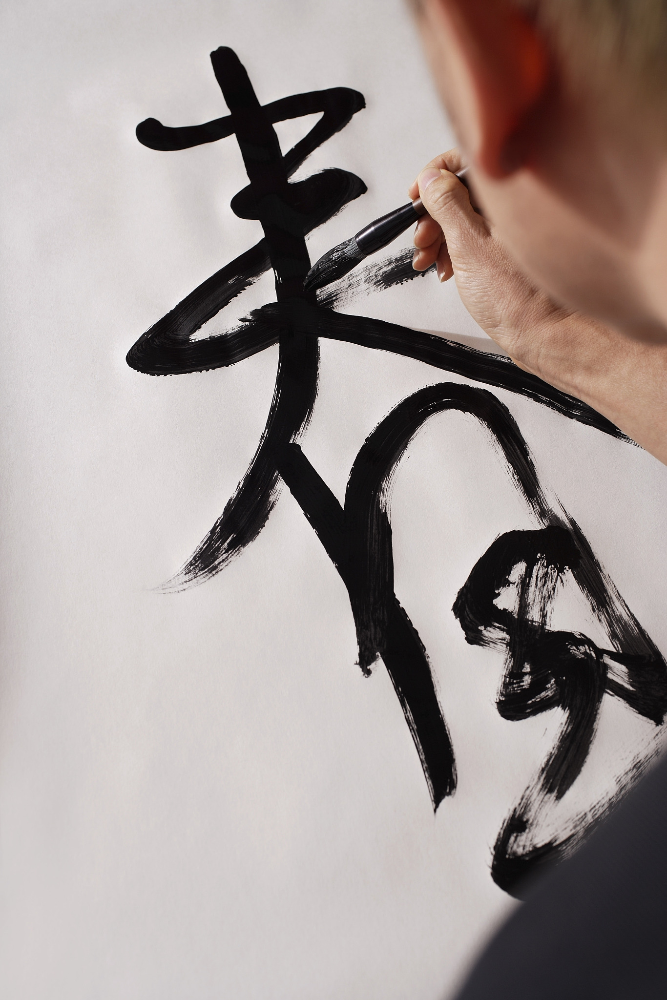 man writing chinese calligraphy,character for spring