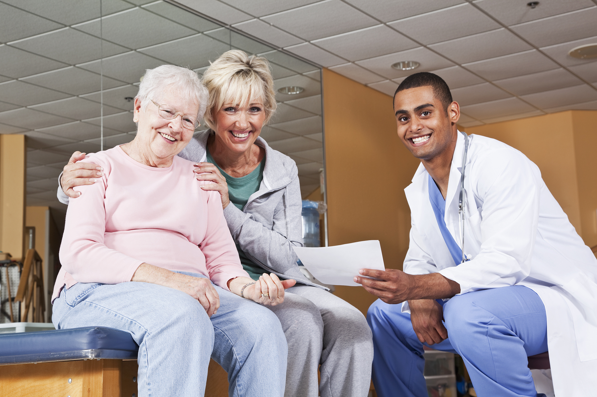 senior woman and adult daughter with physical therapist