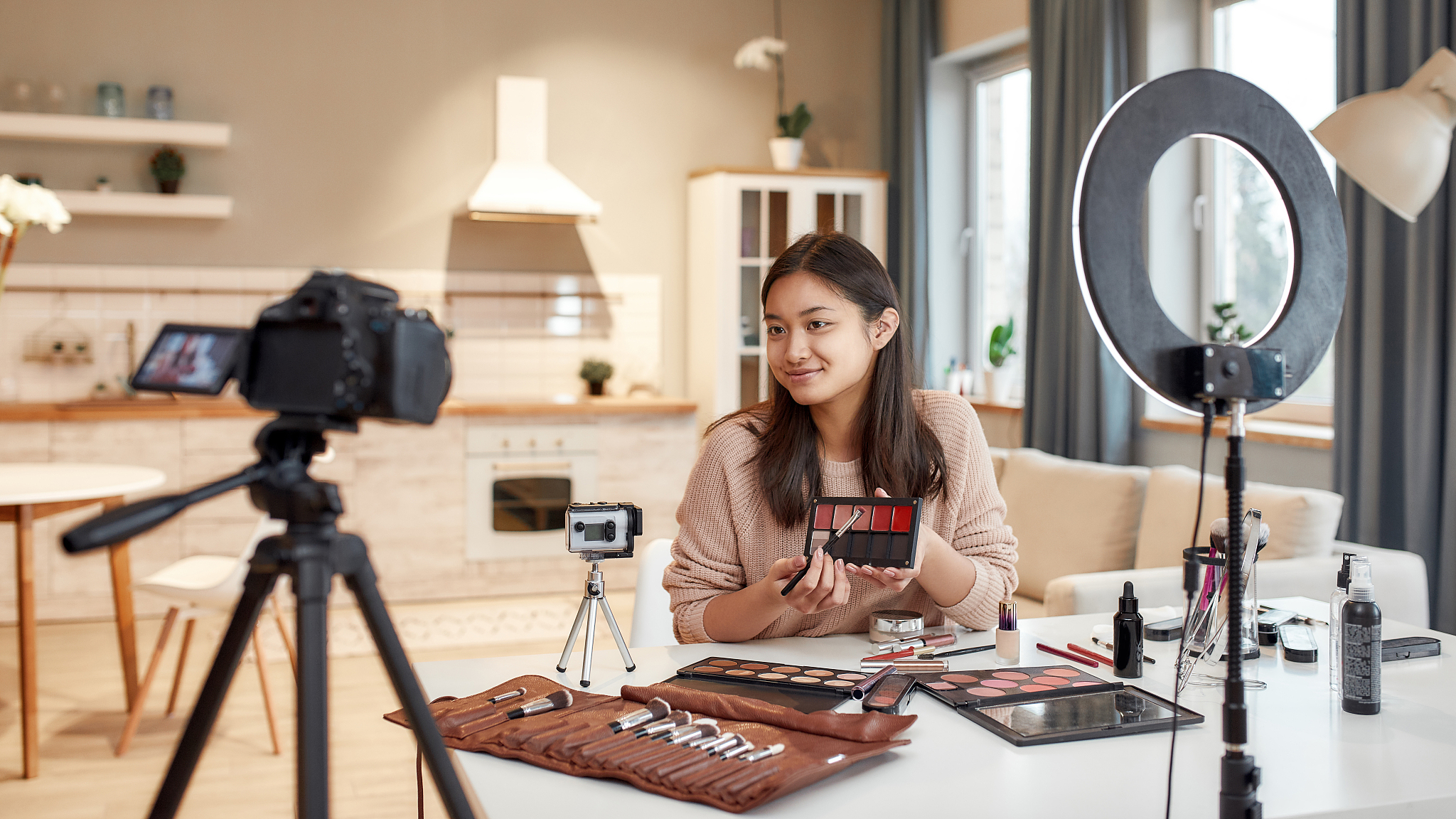 this is the future. asian female blogger showing cosmetic produc
