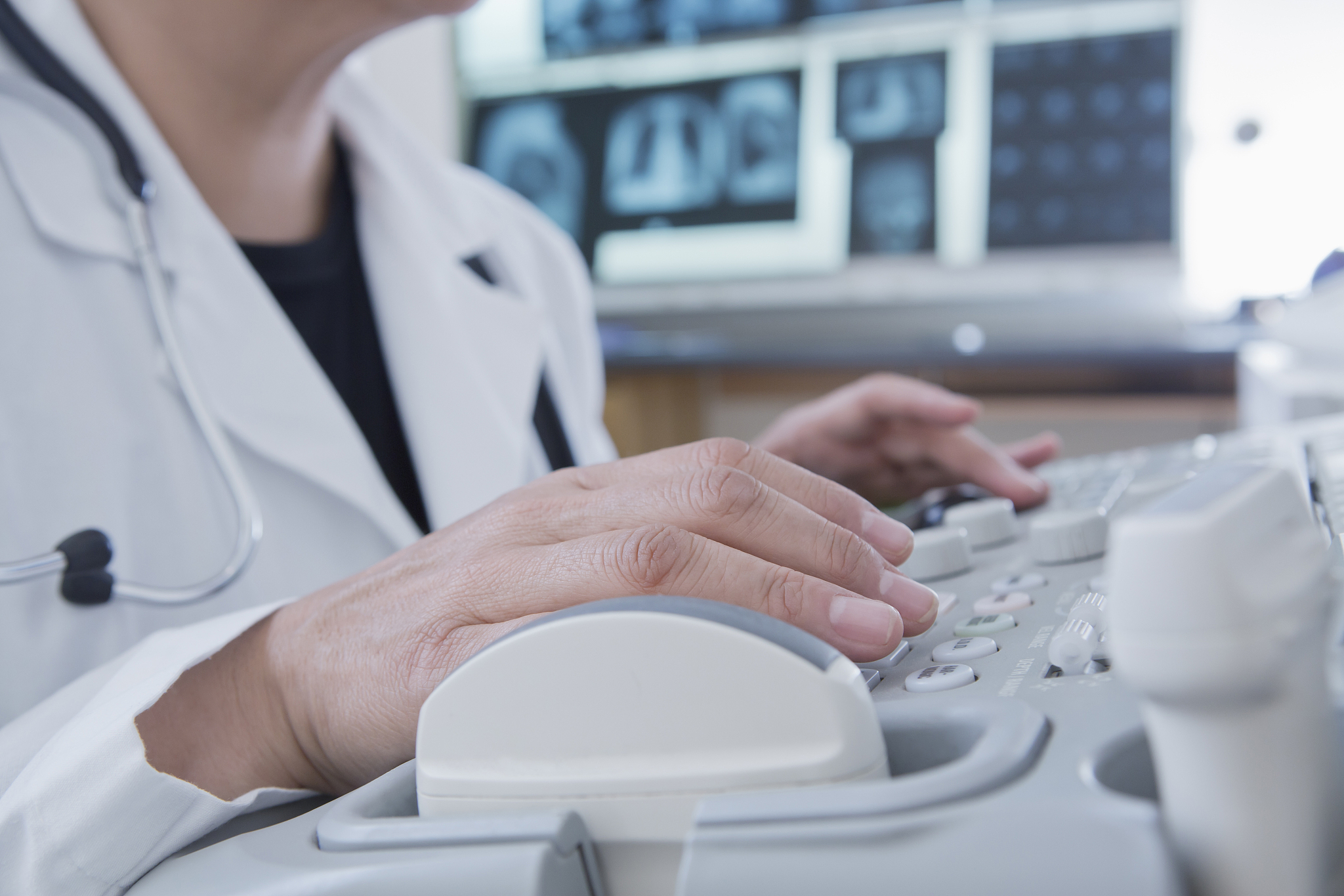 hispanic doctor using machinery in hospital