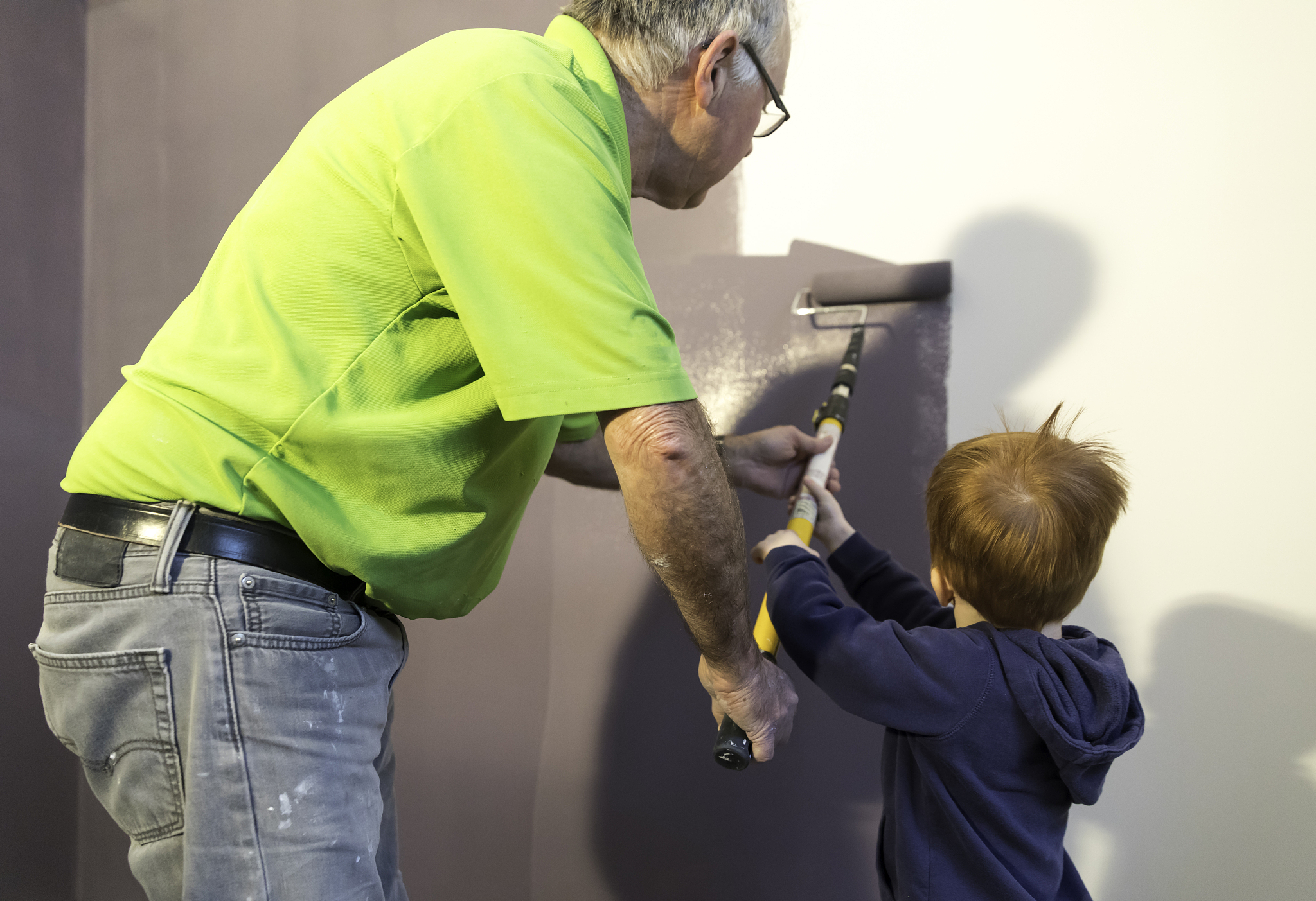 grandfather painting new house with grandson