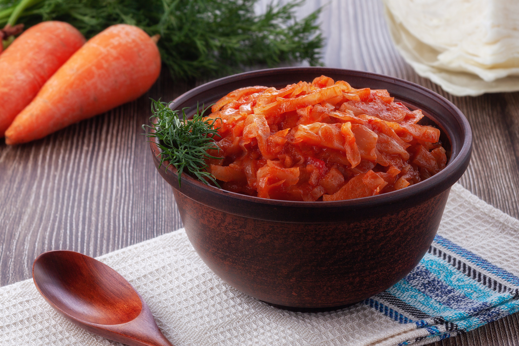 braised cabbage with tomatoes on an old wooden background in rus