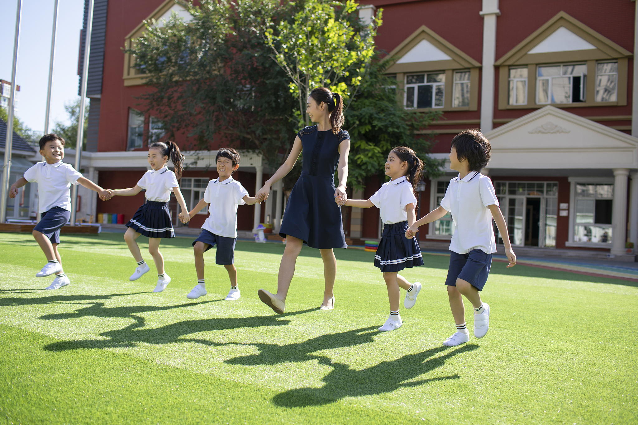 幼儿园老师和学生在操场上