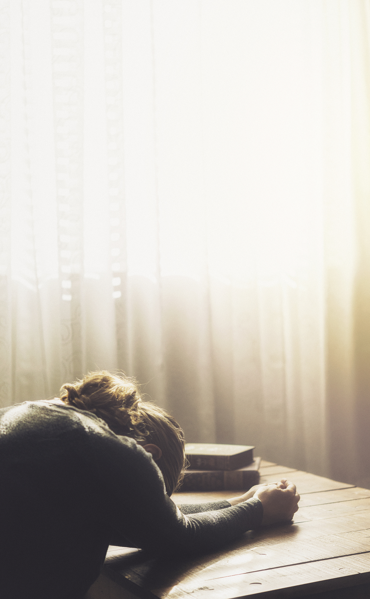 stressed woman sitting in loft surrounded by bright sunlight