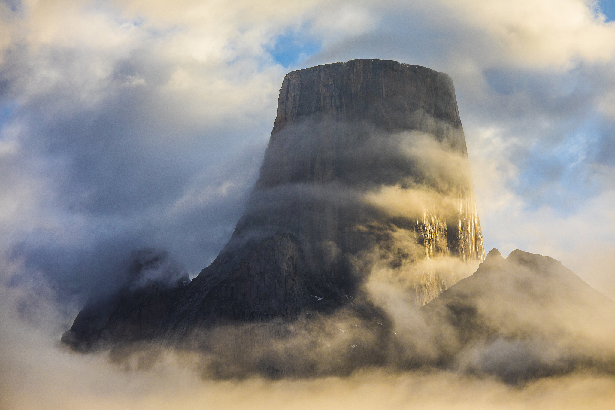 bands of cloud circle mount asgard, baffin island, canada.