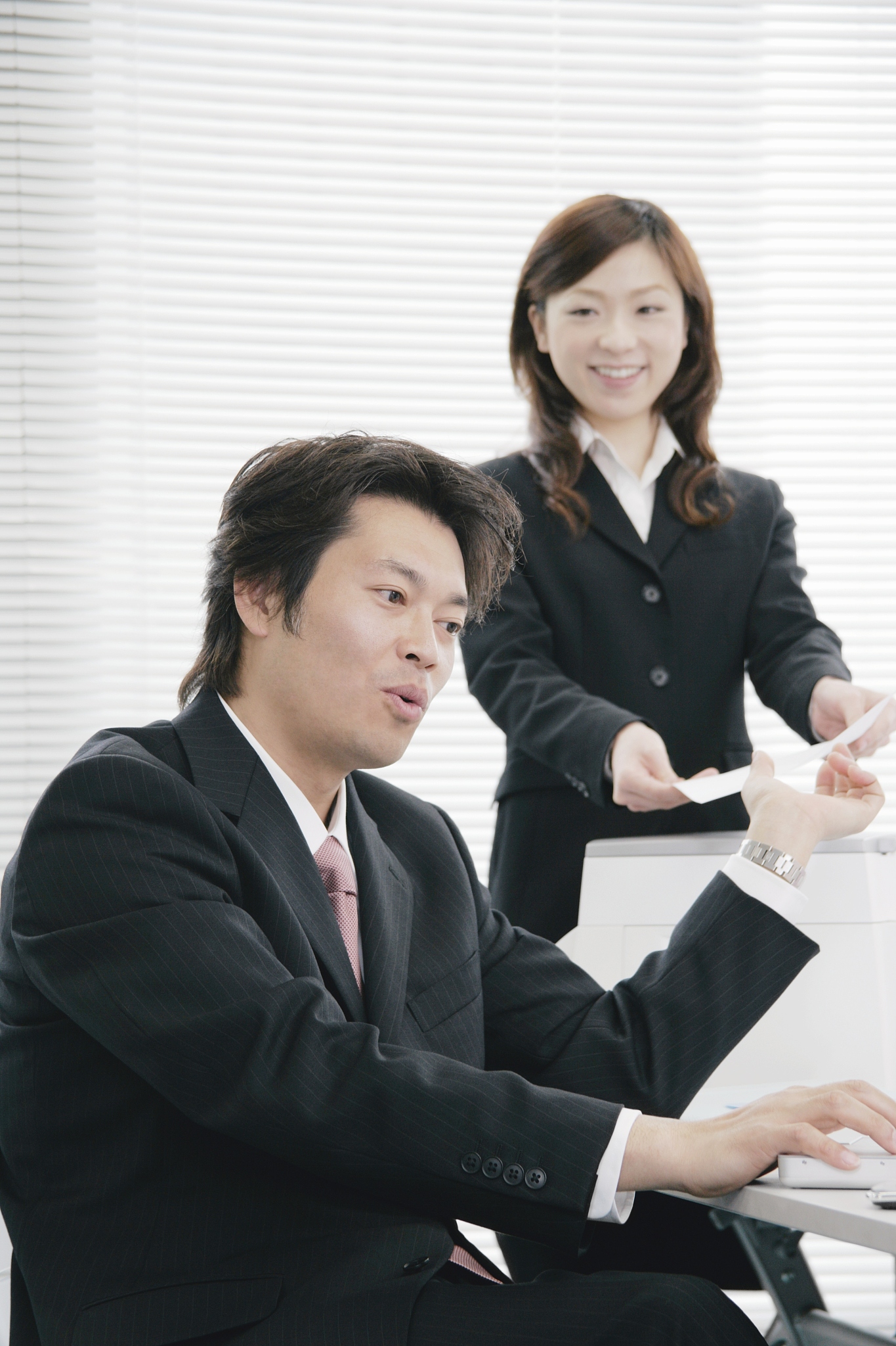 young woman handing document to her boss