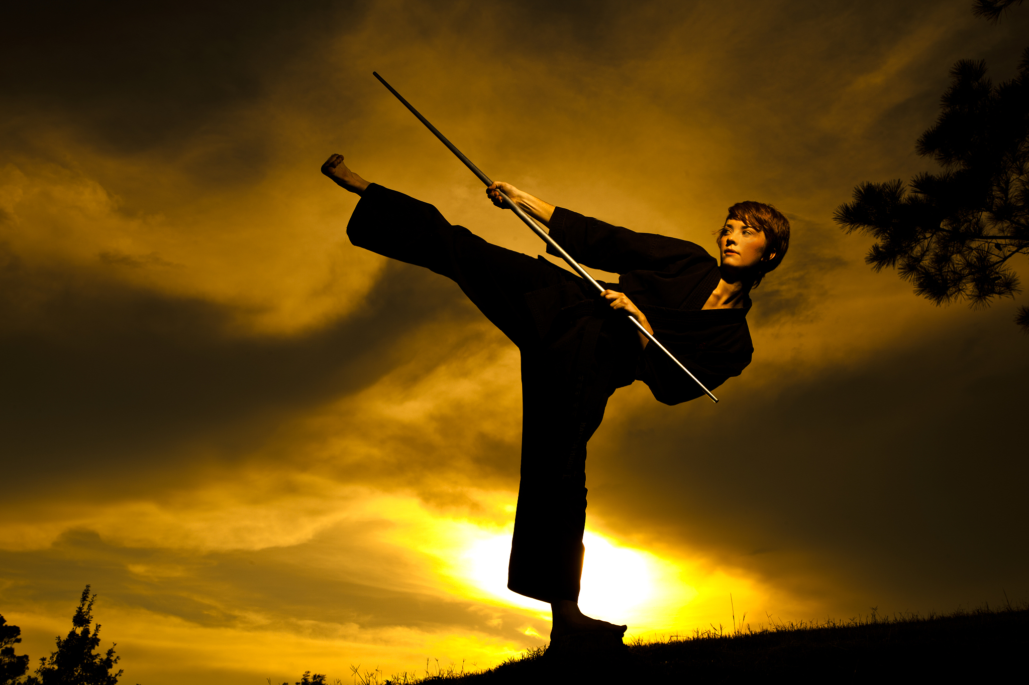 woman in silhouette practicing martial arts, karate. sunset. out