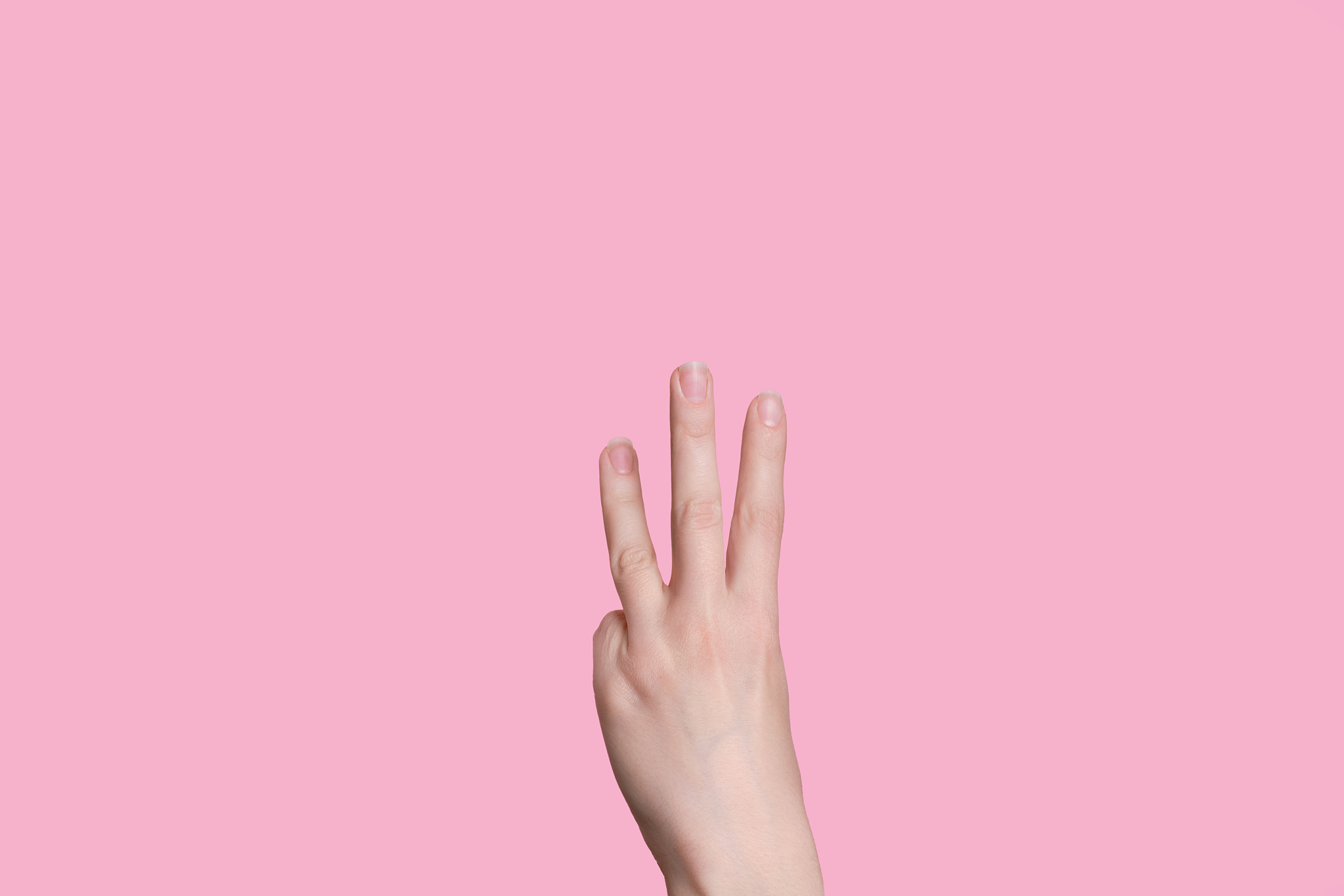 the number three. female hand counts on fingers. the back of the