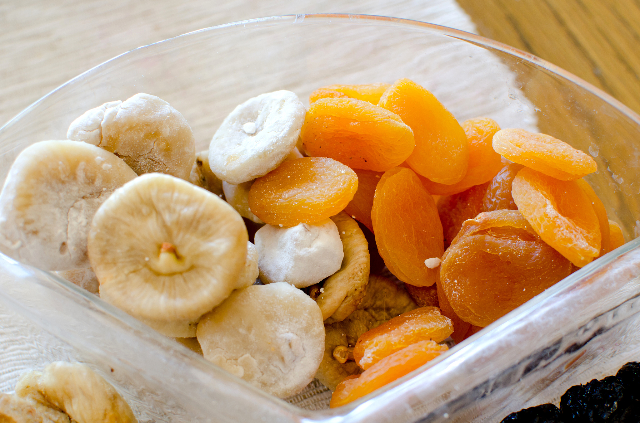 dried figs and apricots in glass transparent bowl