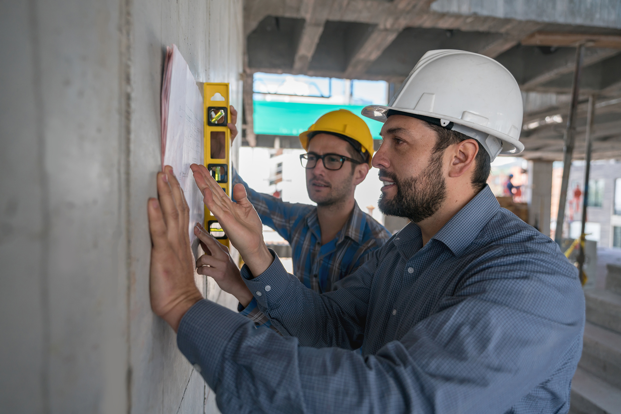 group of architects looking at a blueprint at a construction sit