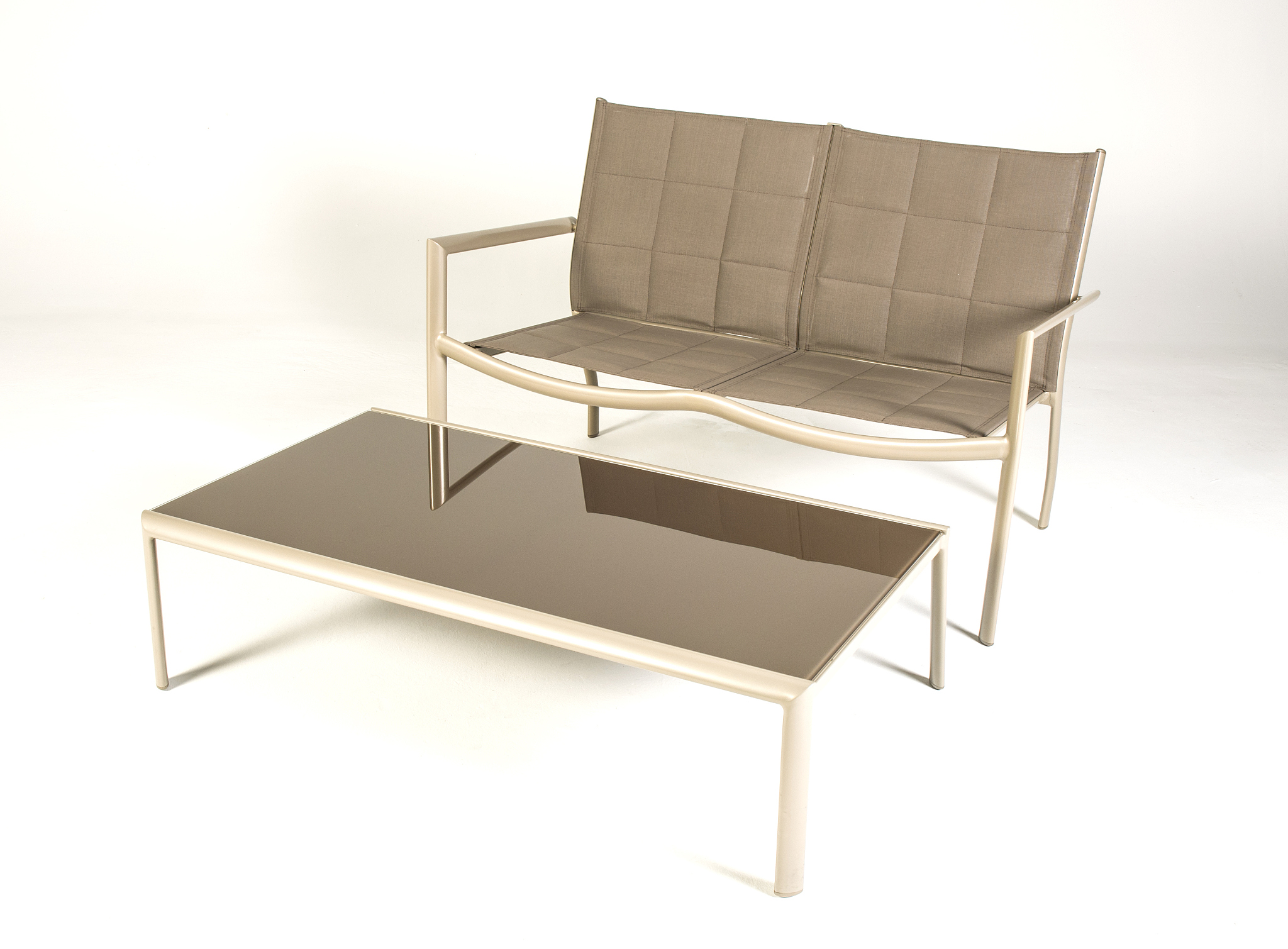 brown patio furniture couch and glass table product shot