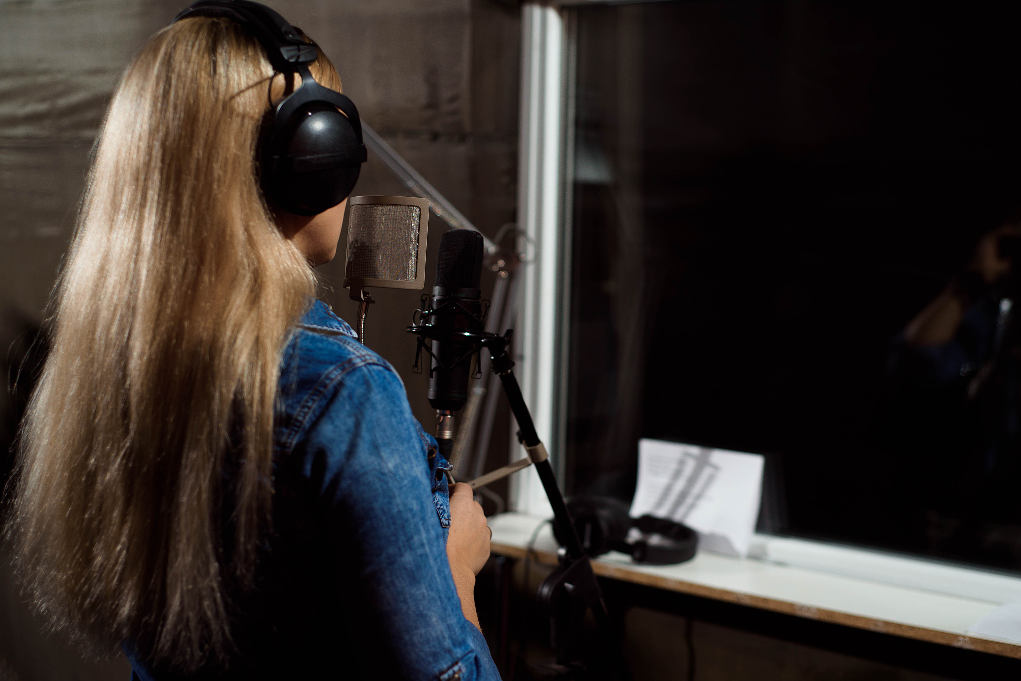 blonde singing woman in a recording studio