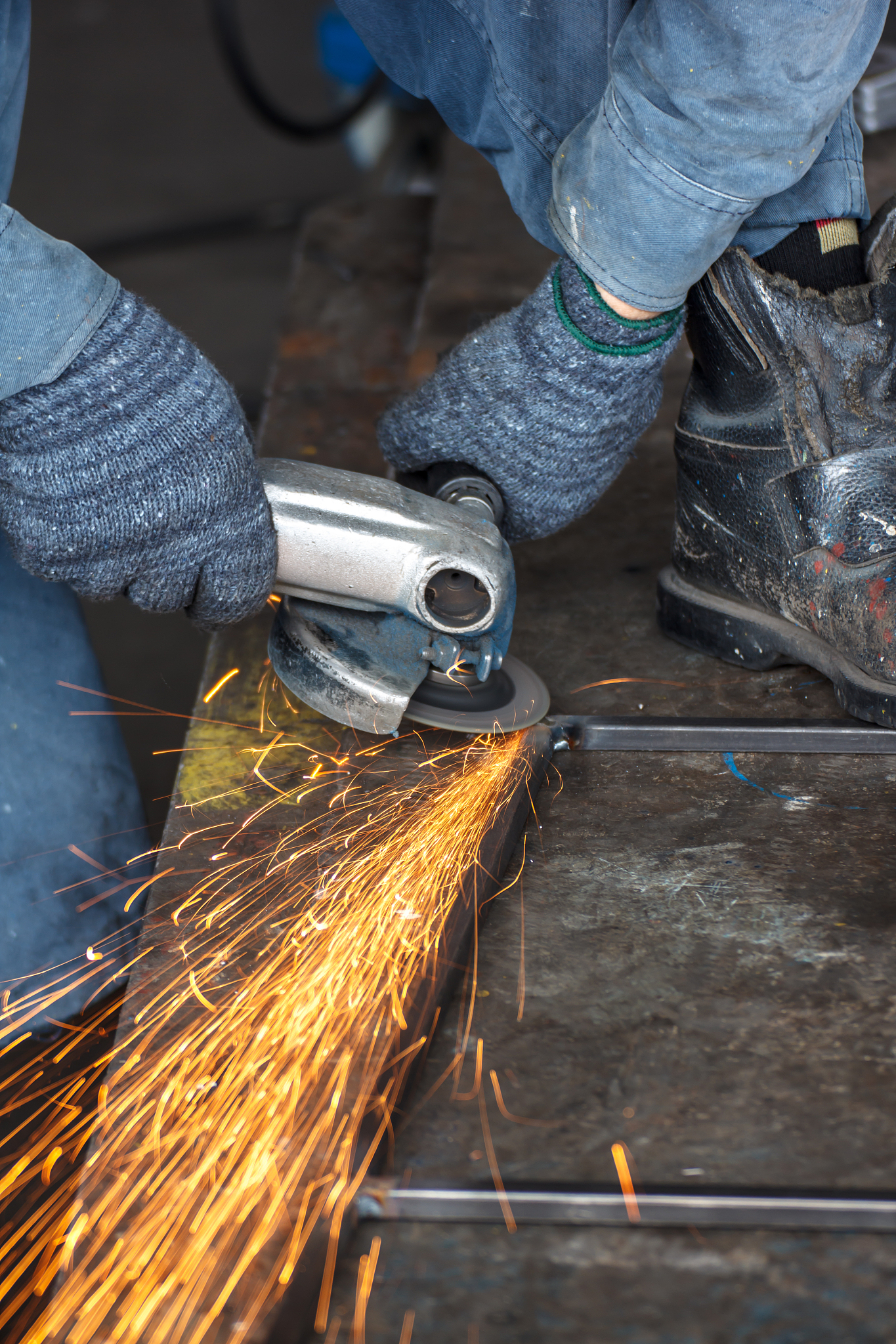 worker in factory grinding metal
