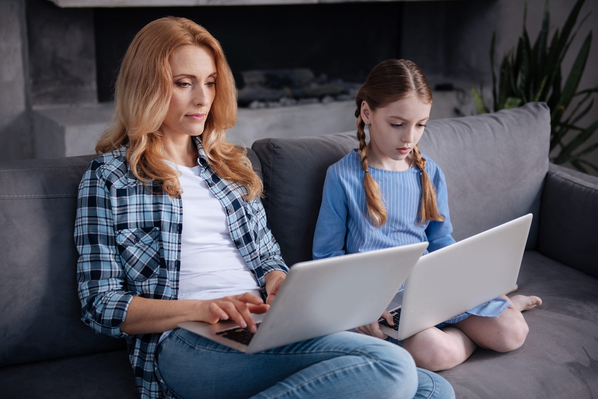 apathetic mother and little daughter surfing the internet indoor
