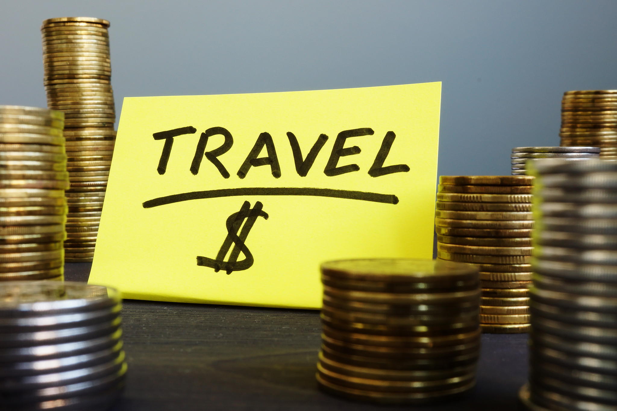 money for travel or vacation. stacks of coins and   stick.
