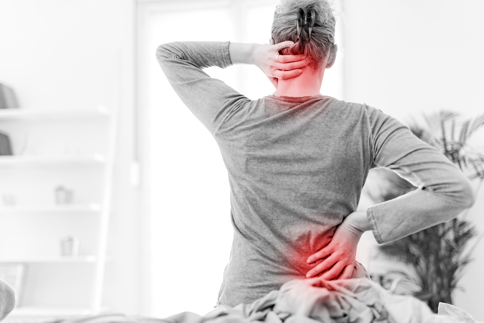 woman waking up on the bed, morning stretching, pain in the back