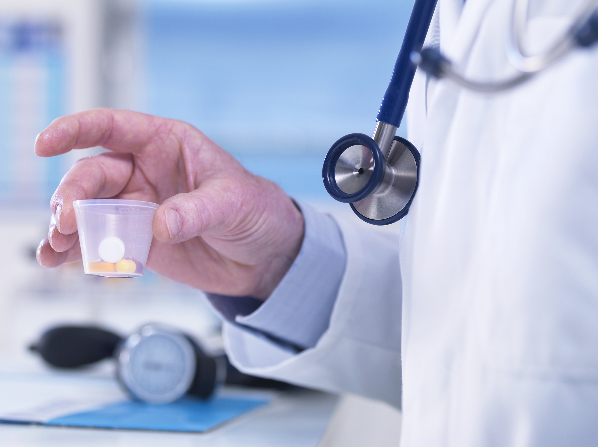 doctor passing a cup of drugs to a patient
