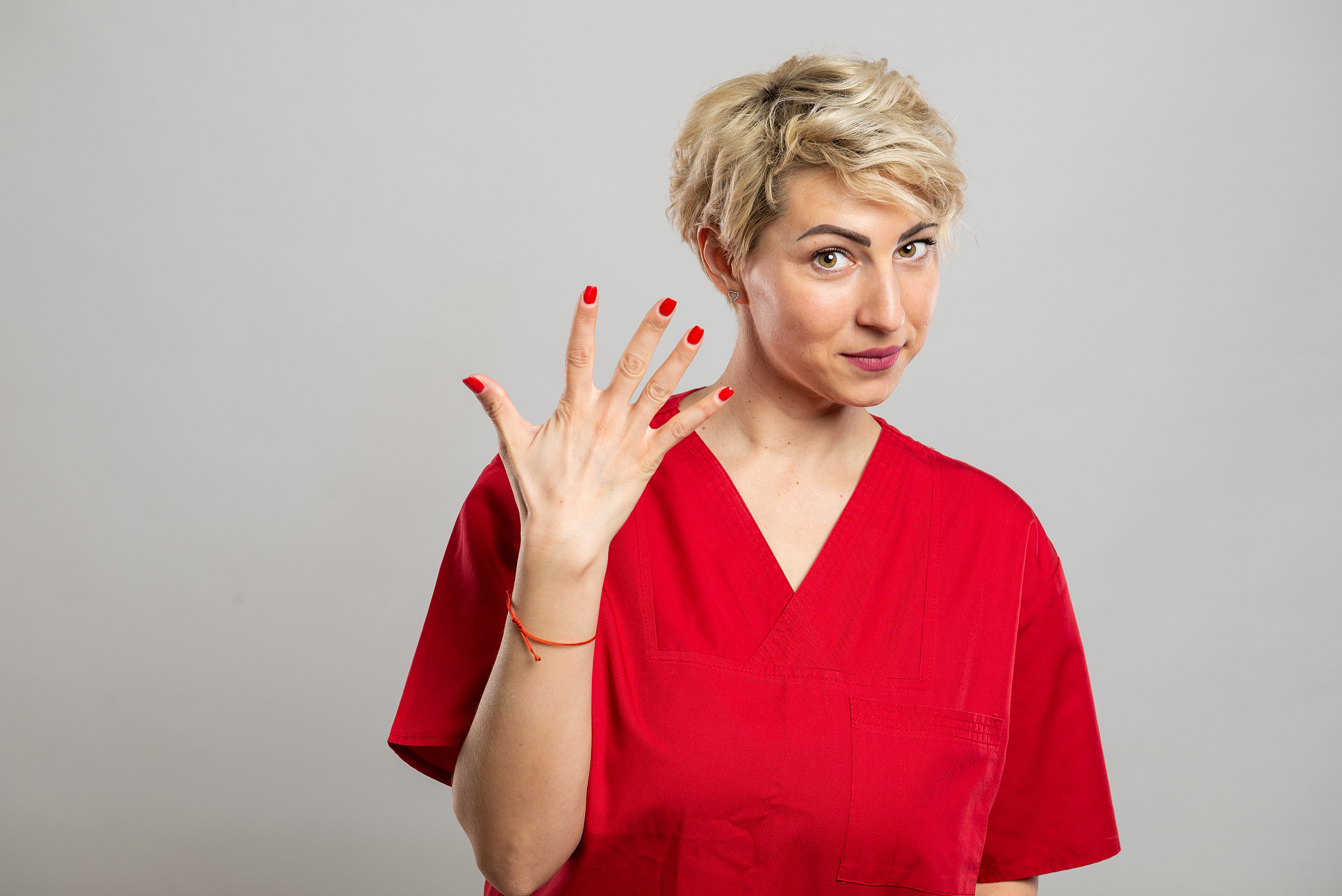 portrait of young attractive female nurse showing number five