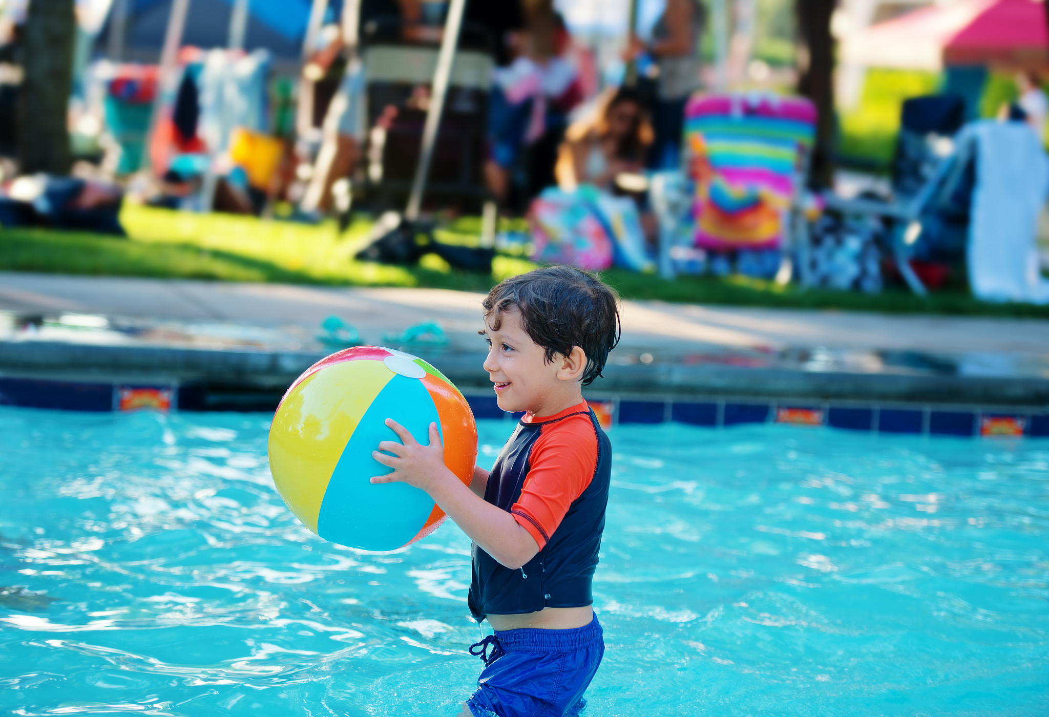 boy in pool with beach ball