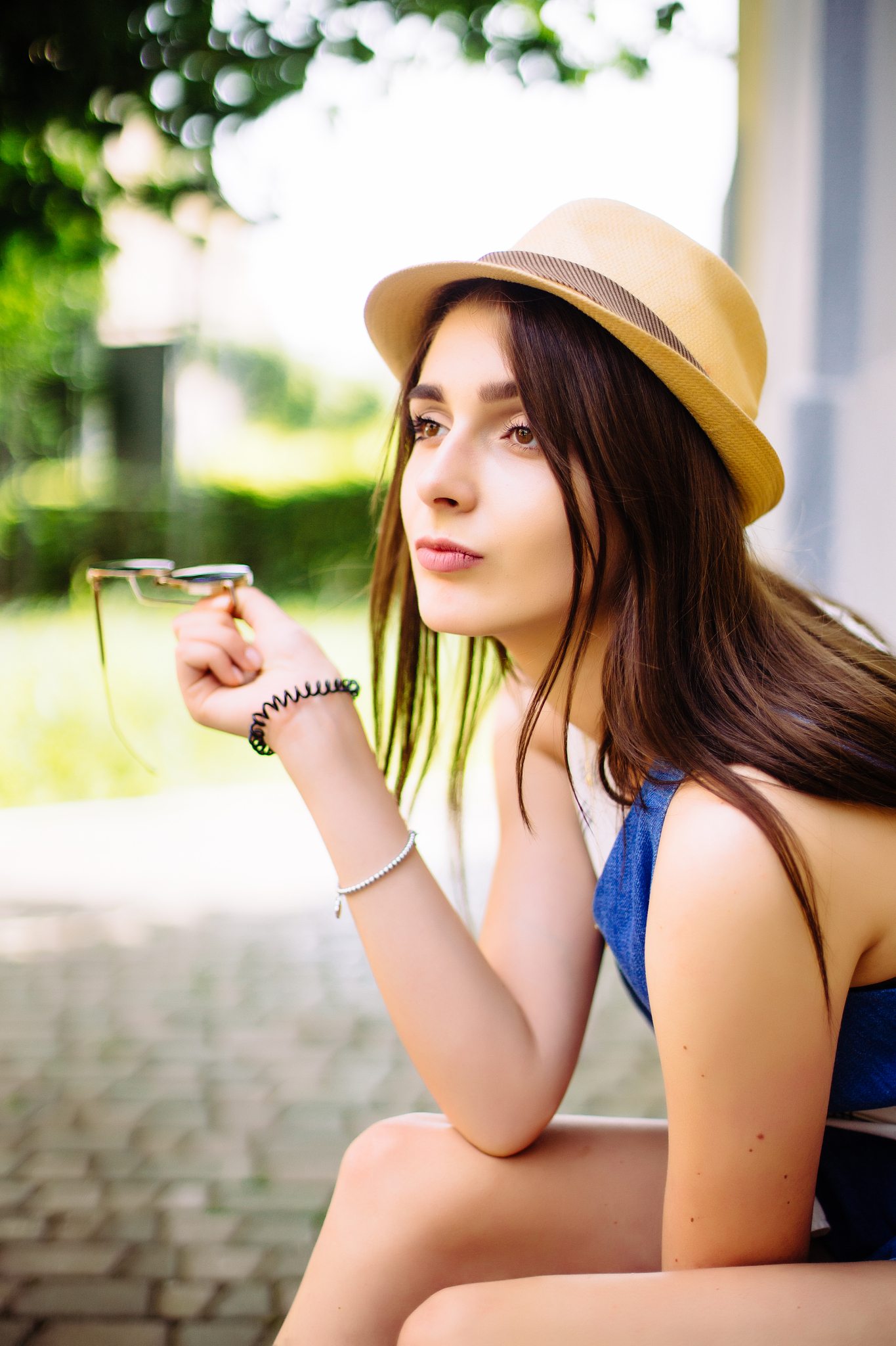 pretty young sitting girl, wearing in hat and sunglasses