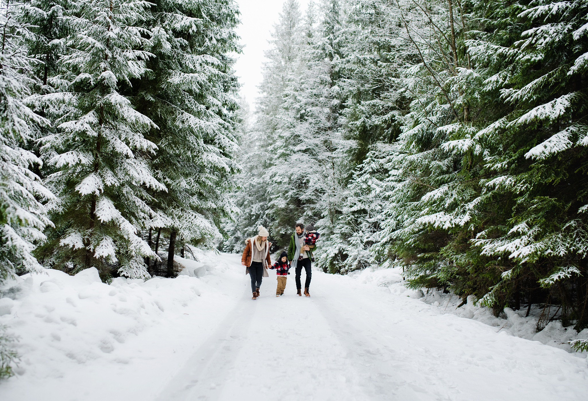 portrait of family with two small children enjoying snow in wint