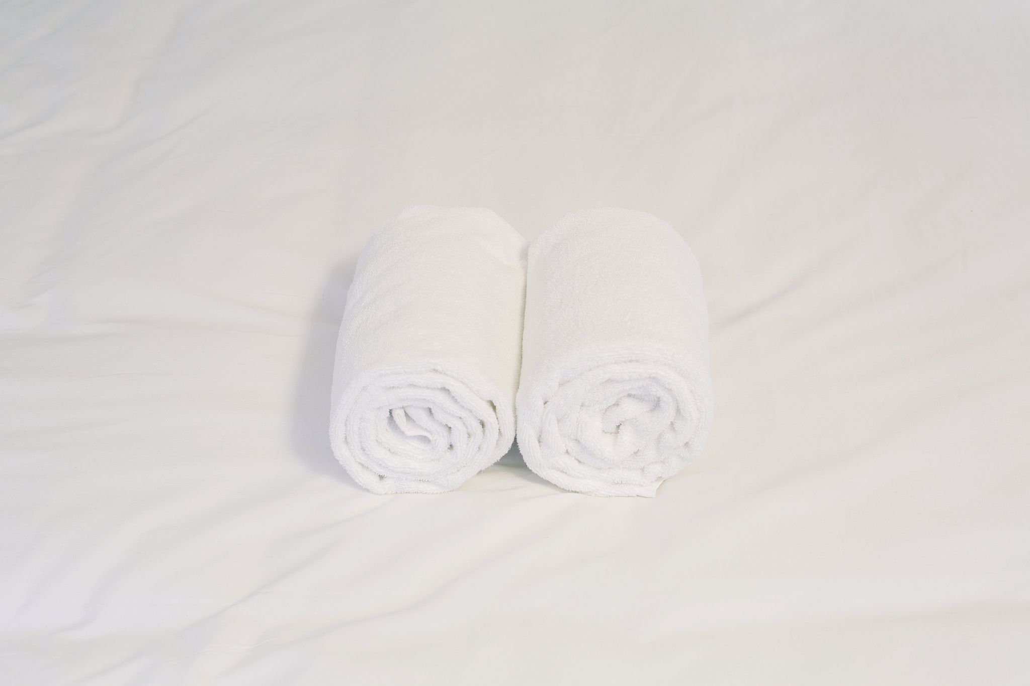 white towel roll on bed