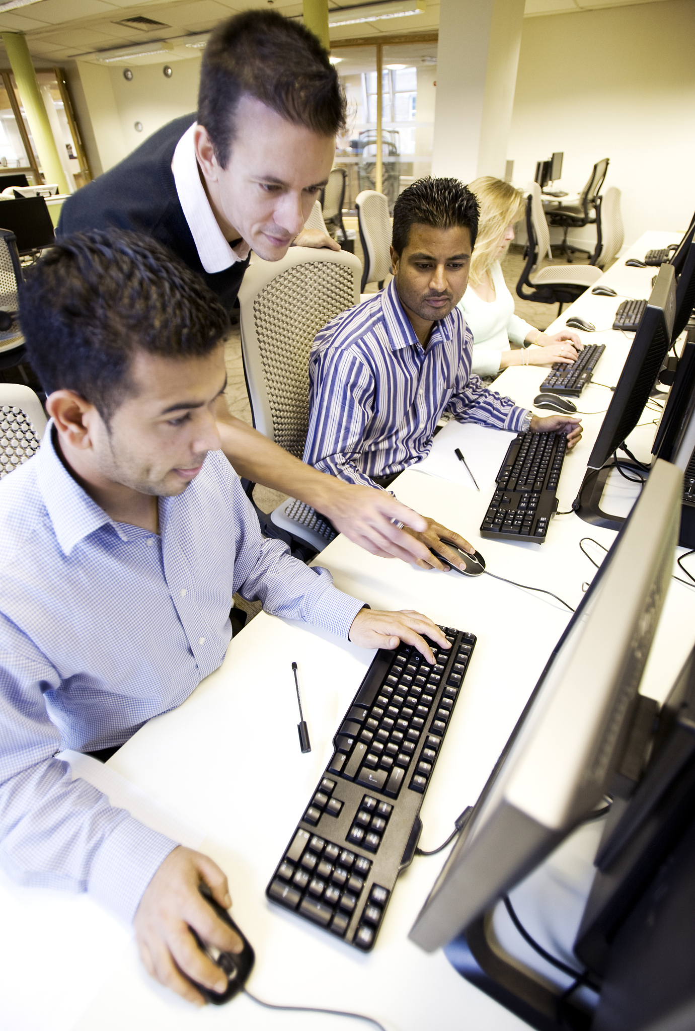 adult education: mature students working together on a computer 