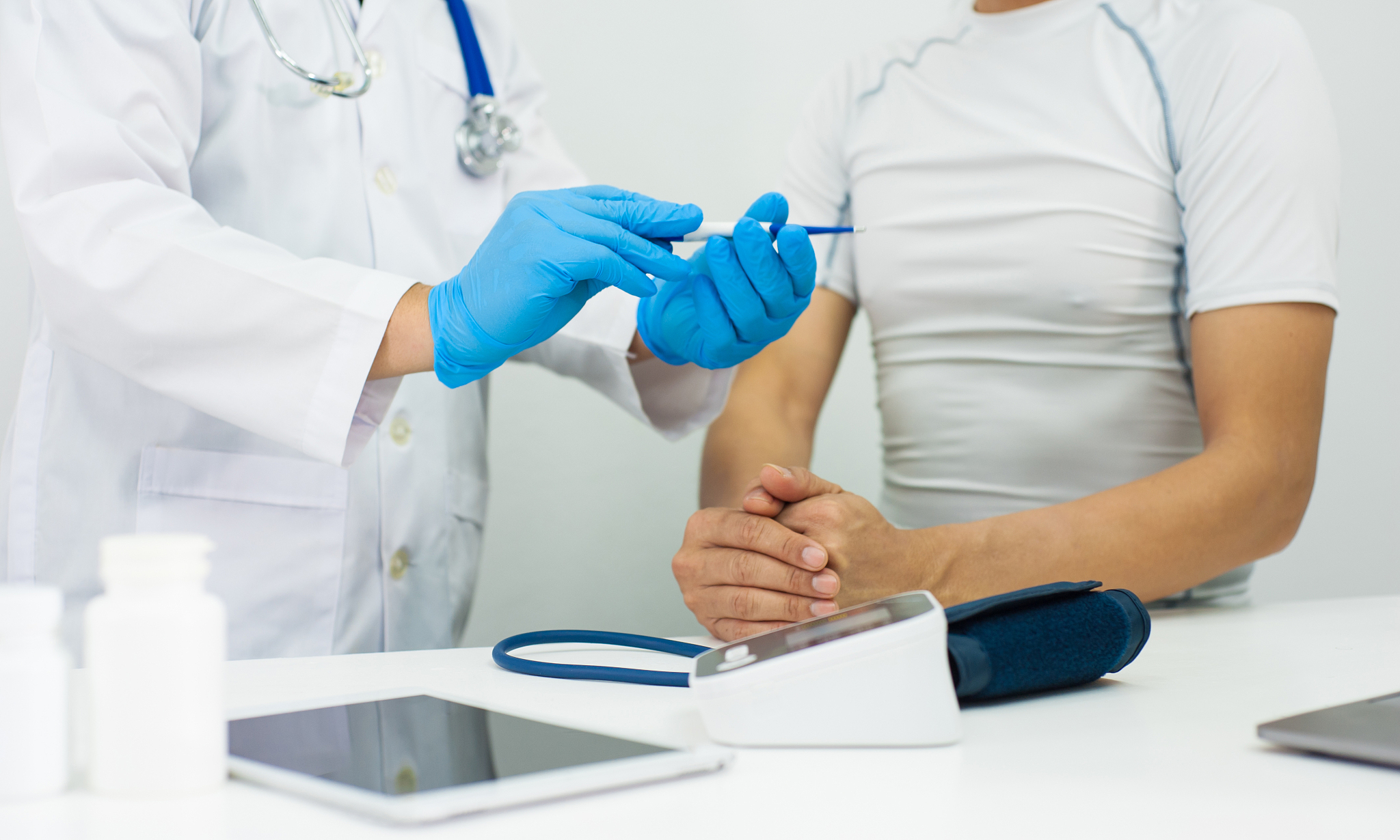 the doctor diagnoses the patient's illness with a thermometer.