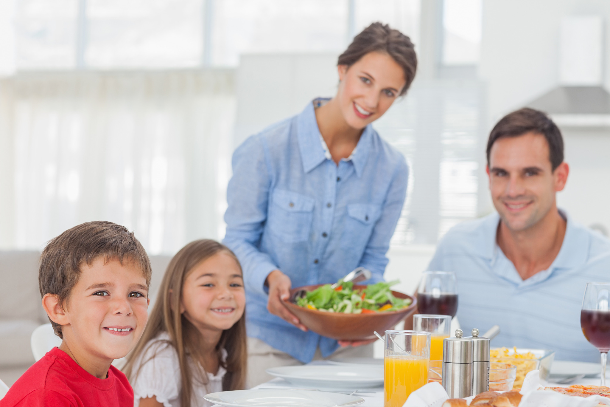 portrait of a woman bringing a salad to her family for the dinne