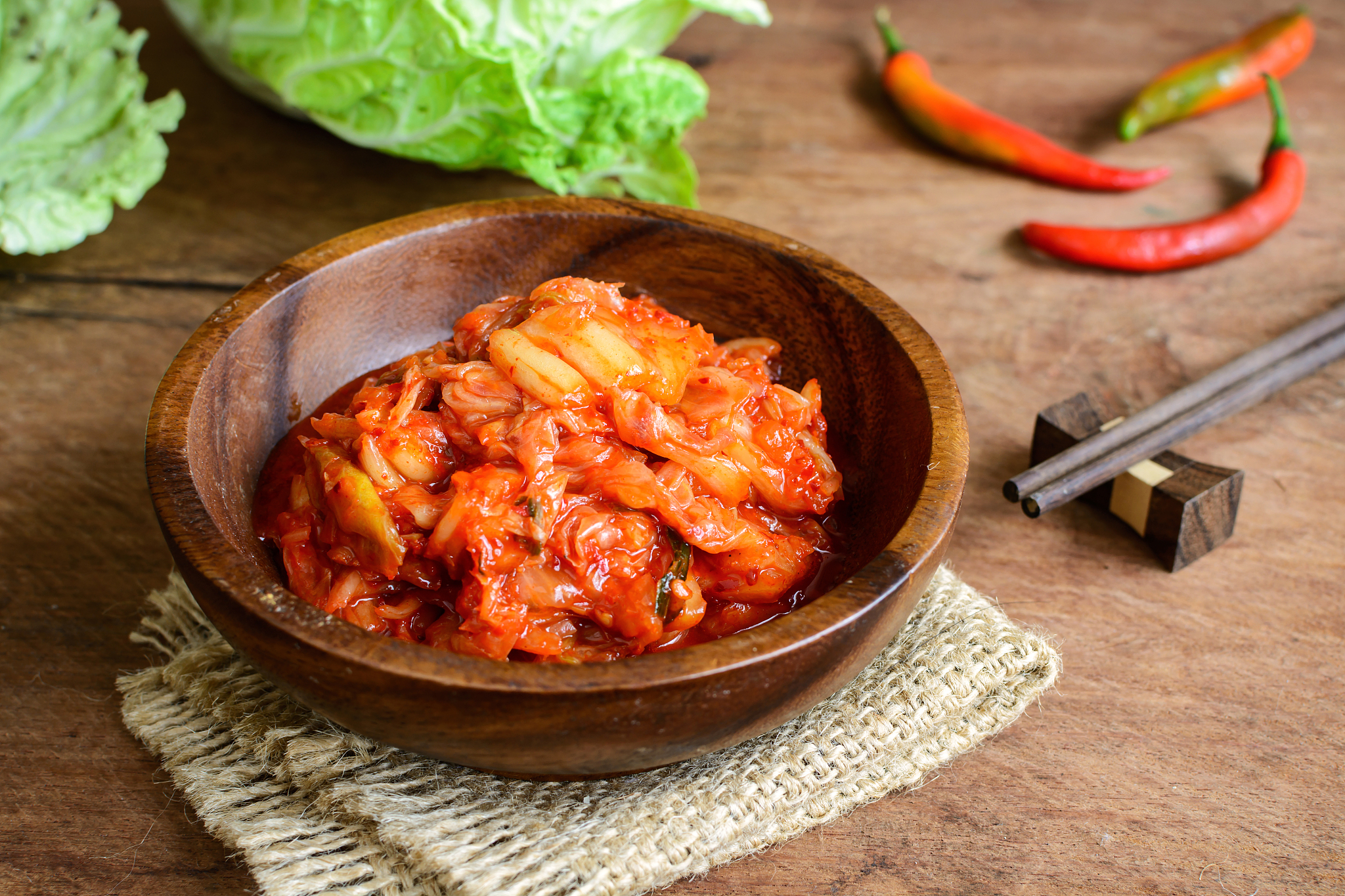 kimchi with chopsticks on wooden table, korean traditional food