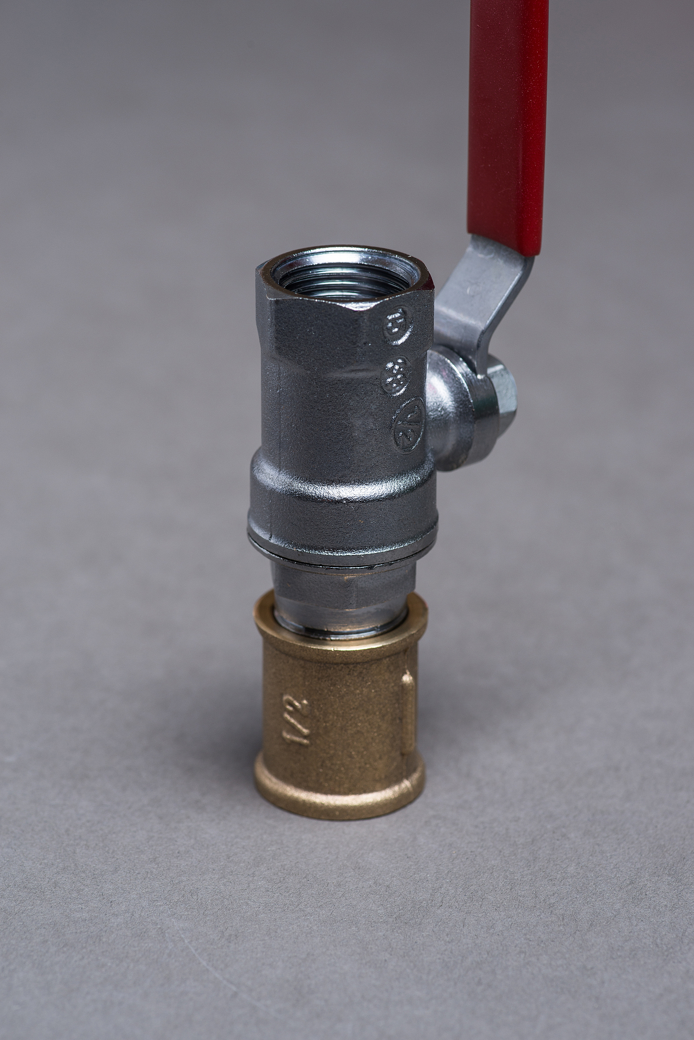 water valve with red handle on grey
