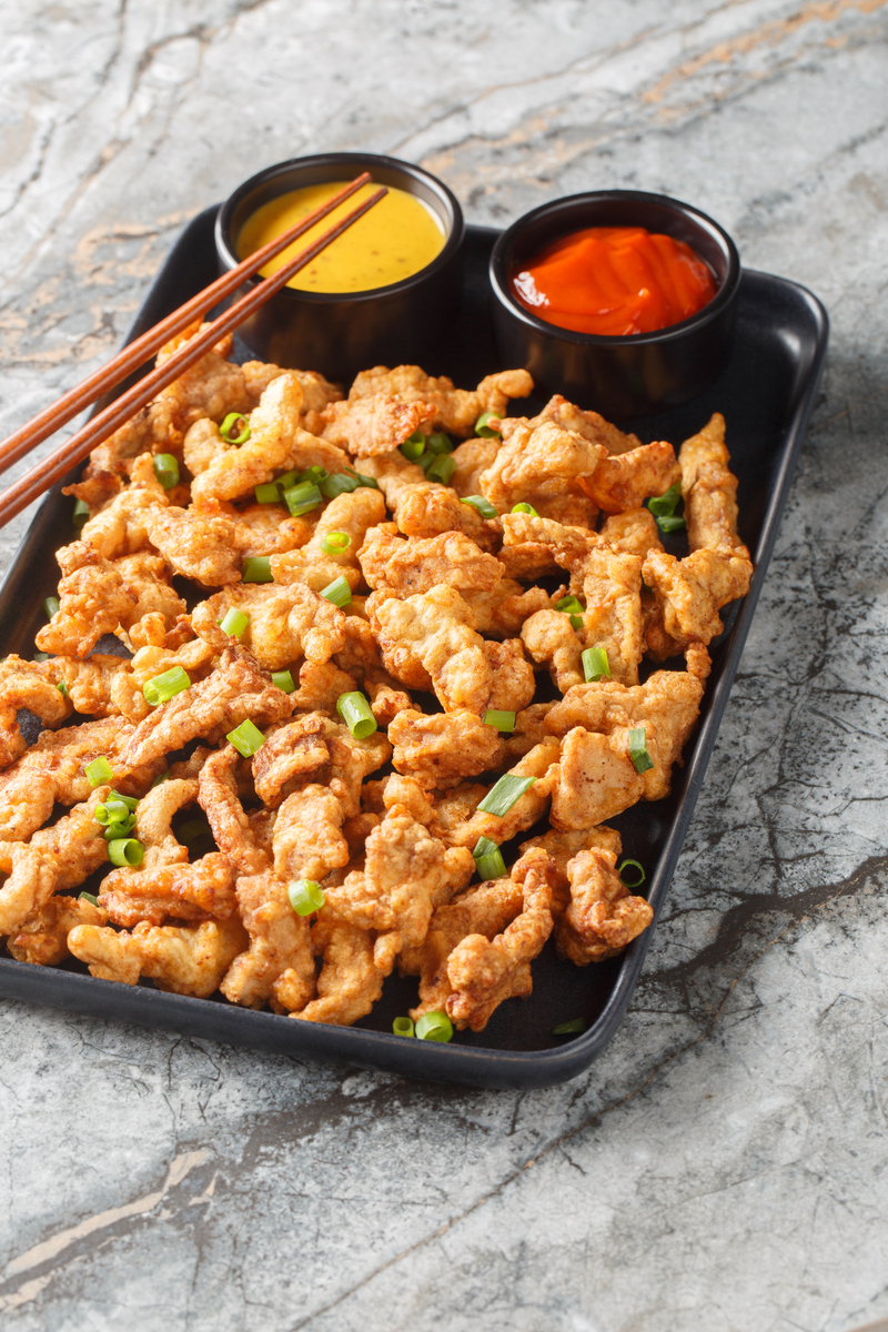 请根据以下模板写一份相似的文案描述更有画面感和诱惑力文字数量大致相同：里脊肉怎么做才好吃呢今天教你一个经典的做法外酥里嫩大人小孩都抢着吃买回来的里脊肉给它切成厚厚的片再用刀背给它敲几下一面敲完再敲另一面切好的猪肉加入适量葱姜水再来半勺盐半勺胡椒粉少许生抽一勺小苏打抓均匀后腌制30分钟酥脆的关键就是倒一袋这个蔬菜粉对比了很多家还是他家的更好吃然后再把腌好的猪里脊放进去裹上一层薄薄的粉再粘一些鸡蛋液重