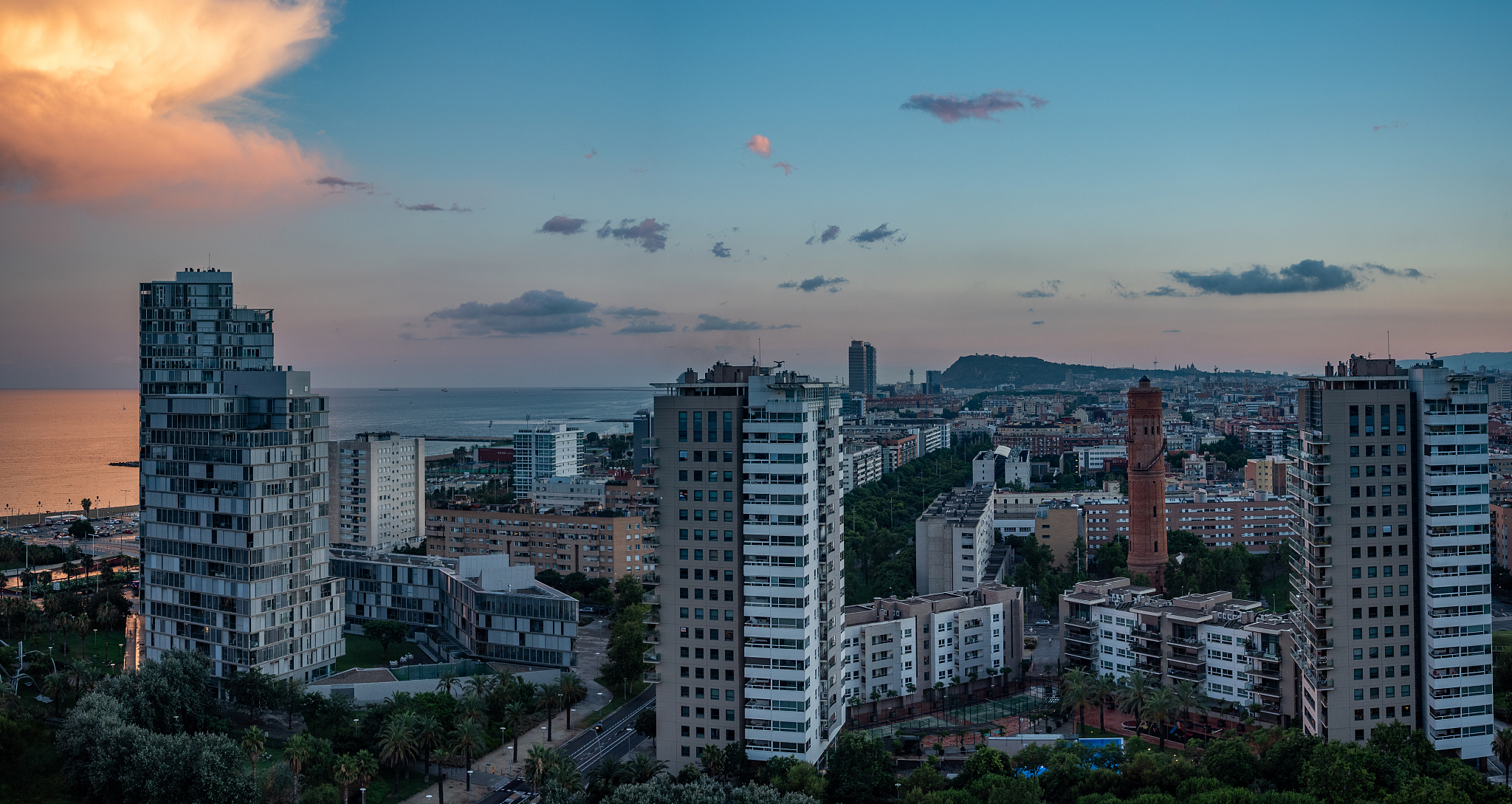 buildings in city against sky at sunset