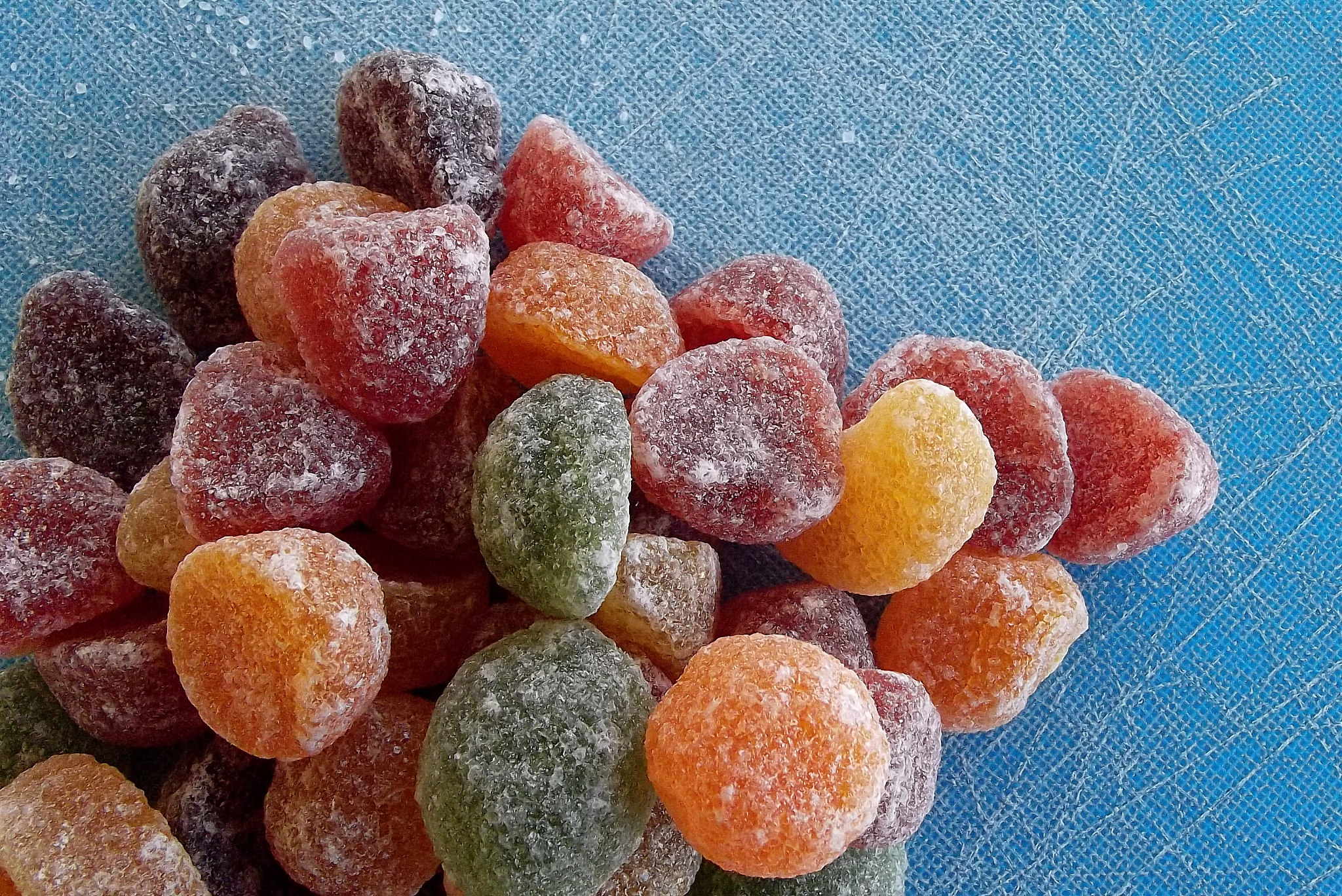 colored gelatin sweets on blue cutting board from above