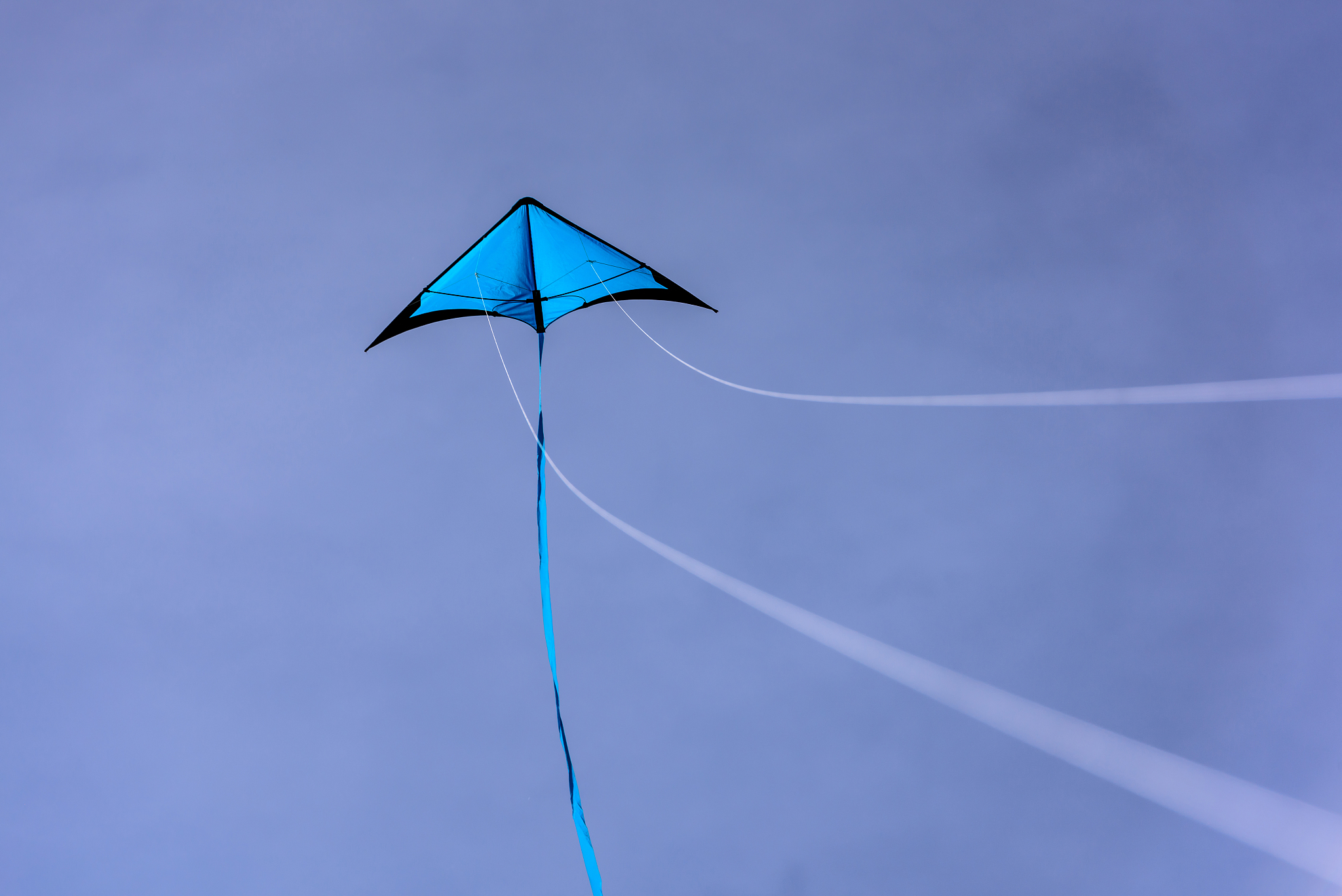 blue kite floating in the blue sky.