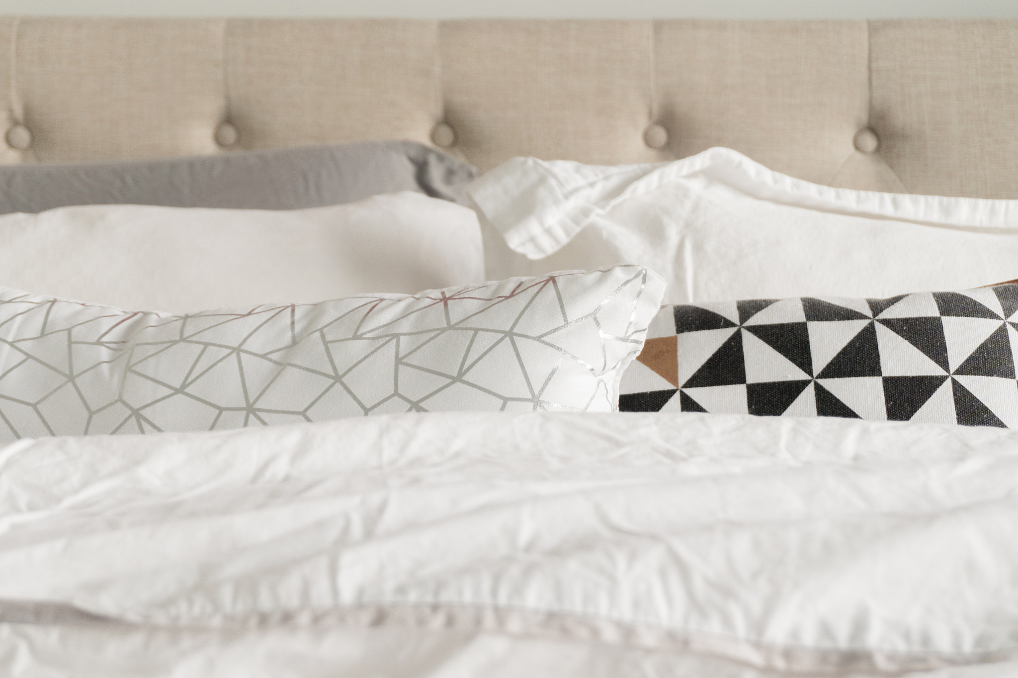 decorative bedding pillows in grey, white, black, gold and white