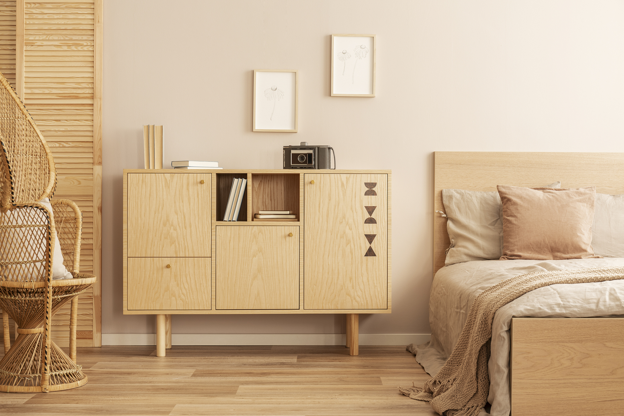 two small graphics in wooden frames on empty wall of stylish gir