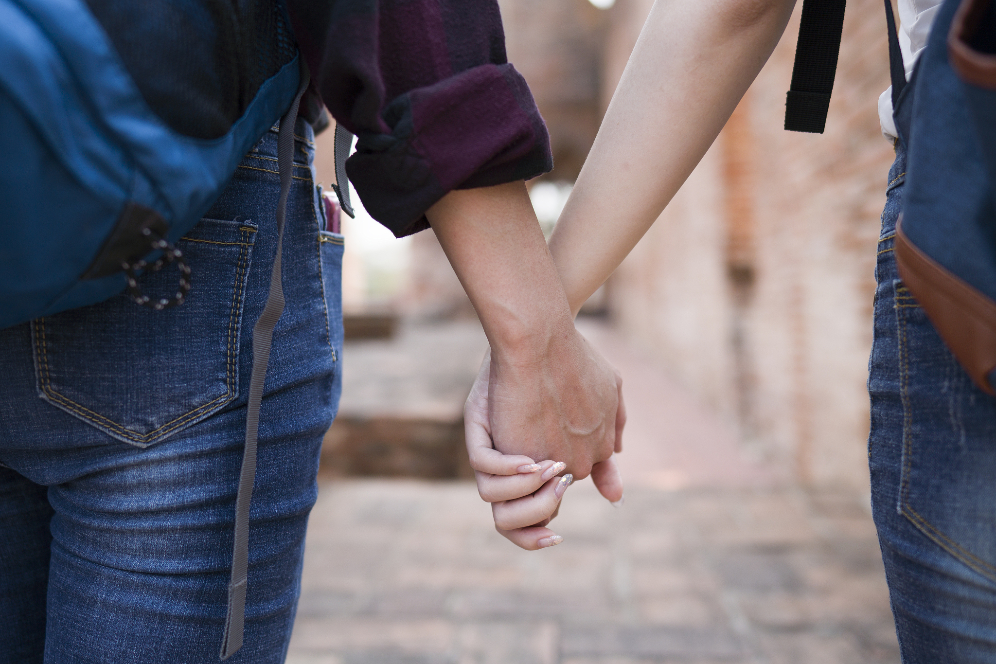 asian tourist holding her boyfriend hand and traveling in wat