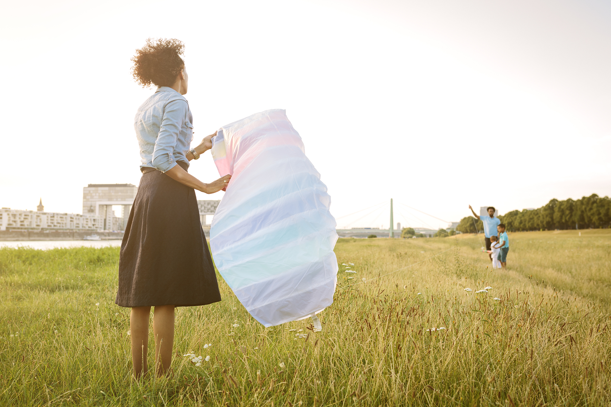 germany, cologne, family flying kite in a field