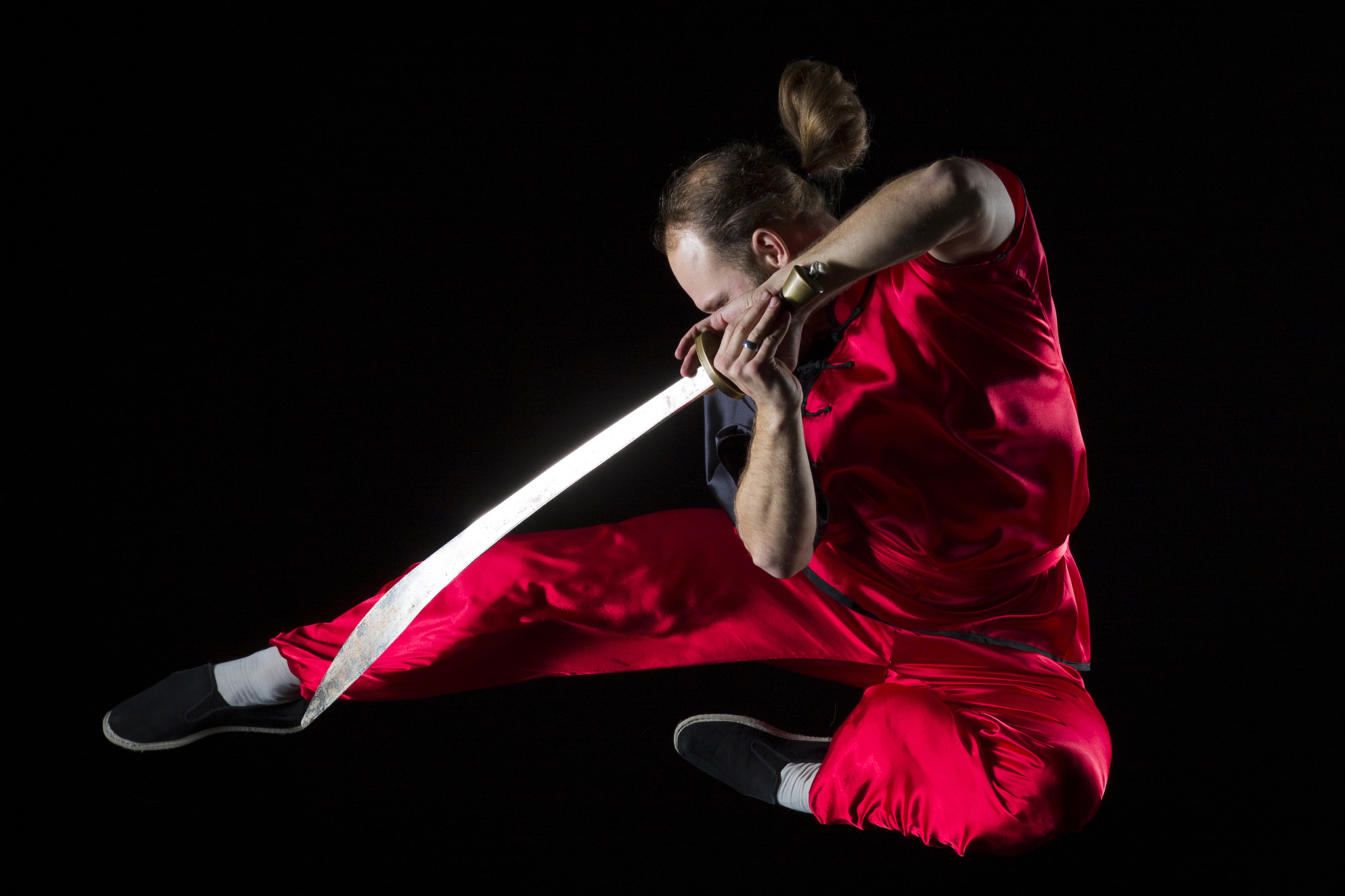 shaolin kung fu fighting position with dao sword in midair