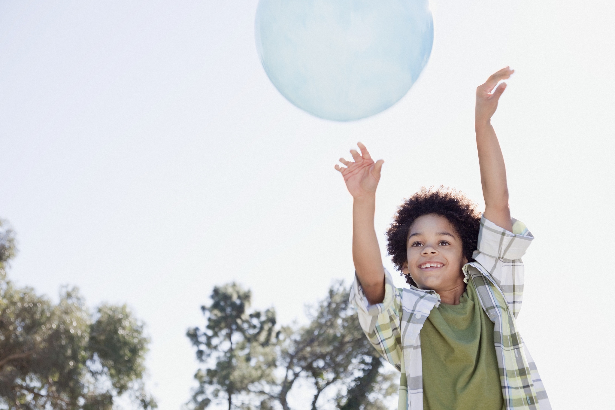 boy (7-9) playing with large ball in park