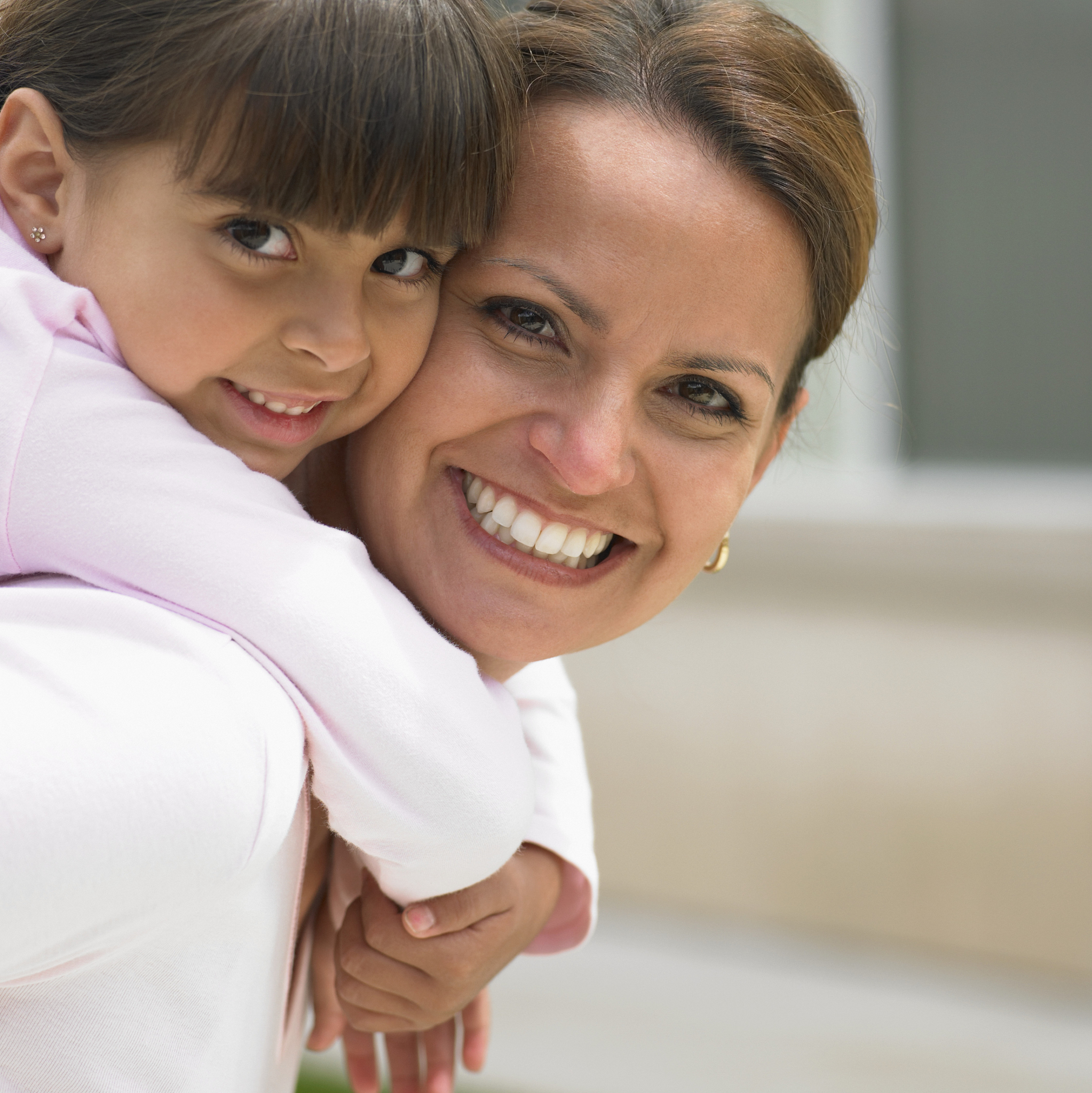 portrait of a daughter riding a piggyback on her mother
